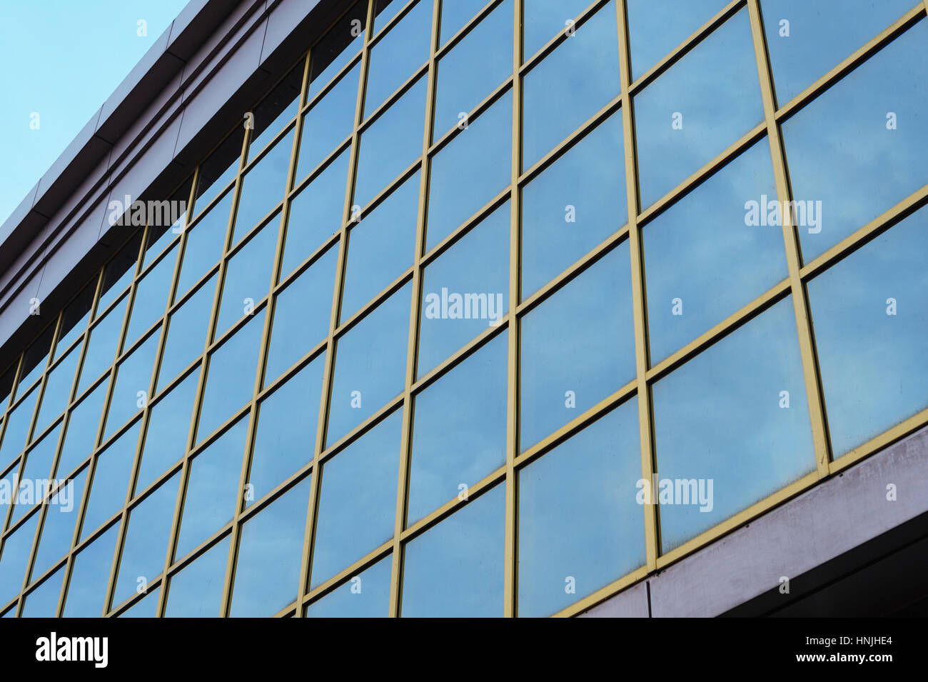 part of a multi-storey glass office building against the sky Stock Photo