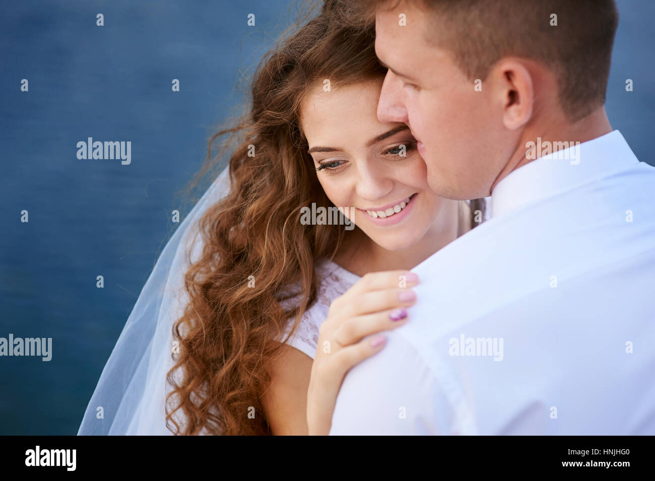 bride and groom embracing at the lake for a walk Stock Photo