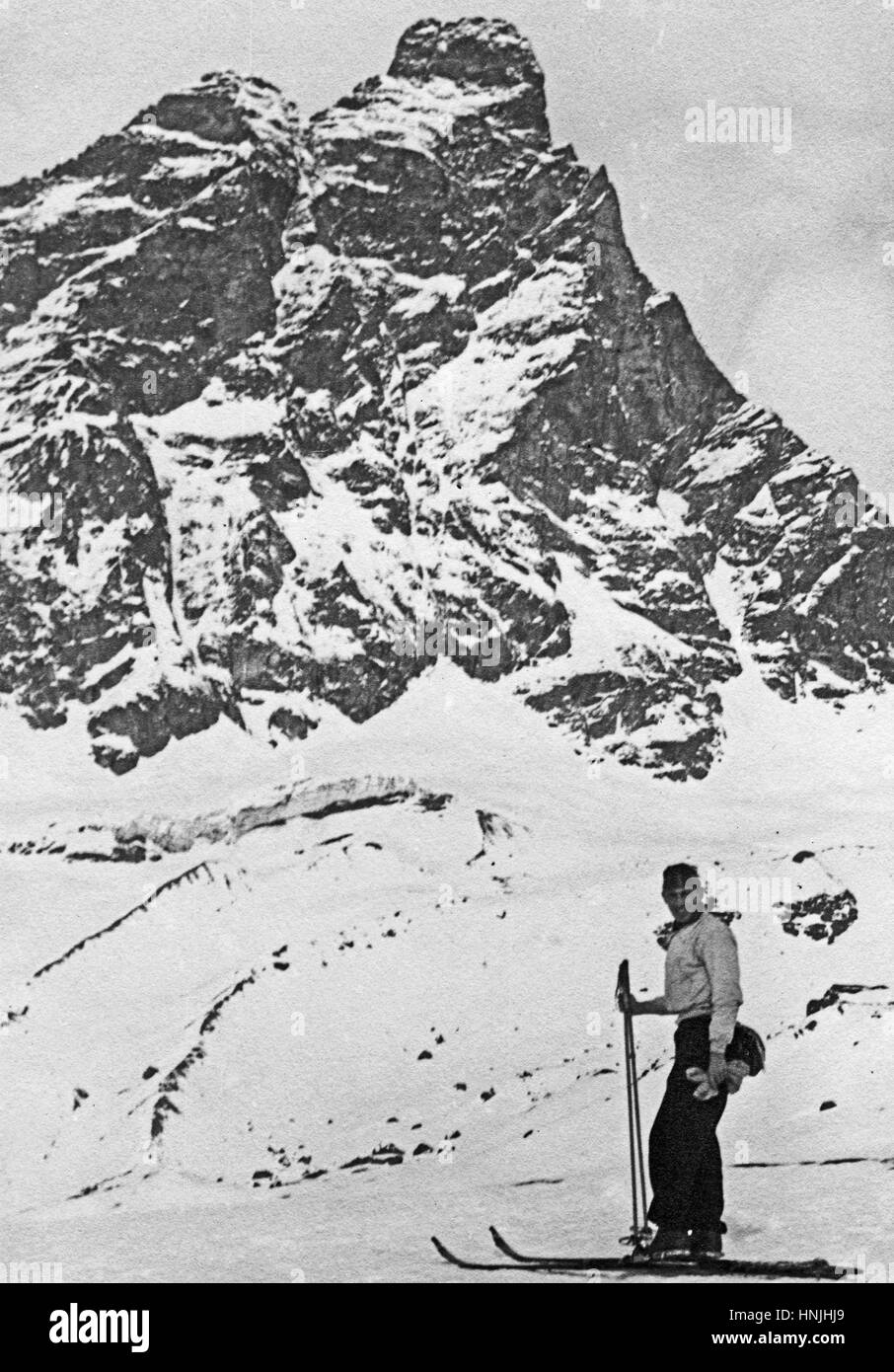 Cortina, Italy - 1939 -Vintage portrait of a skier with a beautiful mountain winter panorama behind. Scan from analog photography, private family collection before WWII. Stock Photo