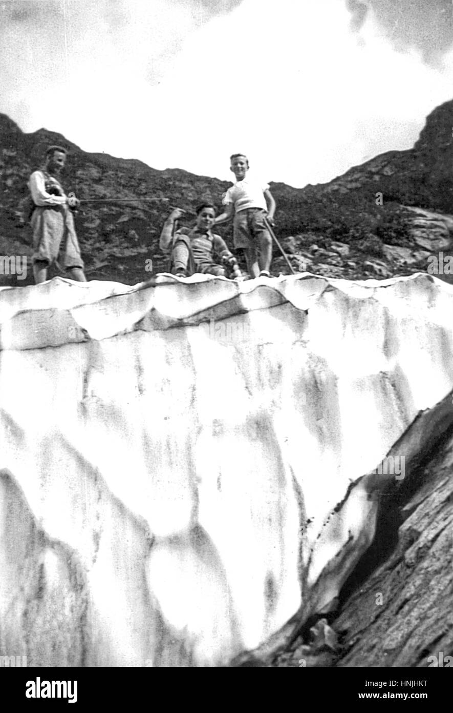 Italy 1934, Portella Pass, 2260 mt,  Appennines - boys in summer vacation, looking down from the edge of a glacier, in central Italy on Appennines mountains .  Scan from analog photography, private family collection before WWII. Stock Photo