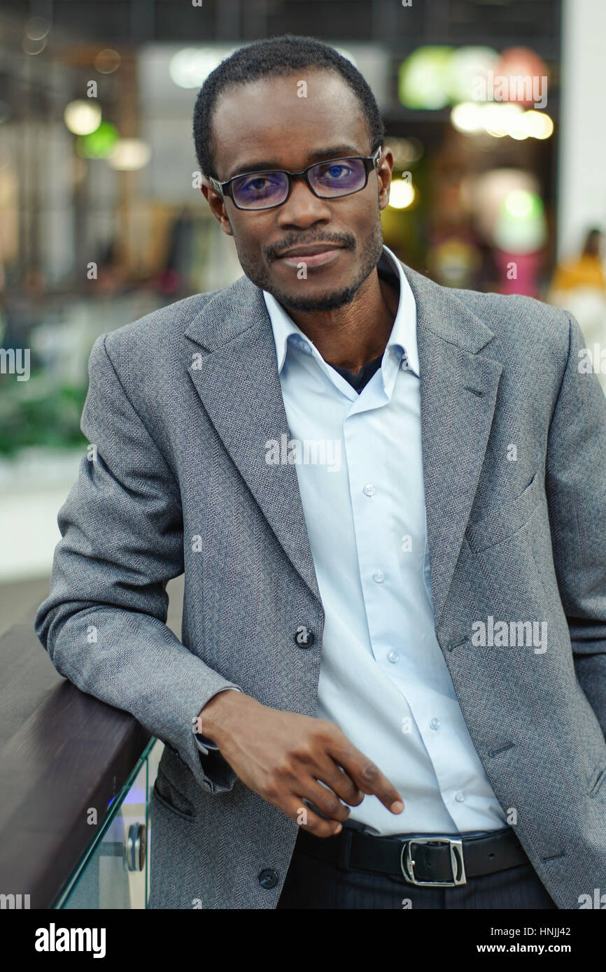 Handsome young afro american man standing near handrails in a shopping ...