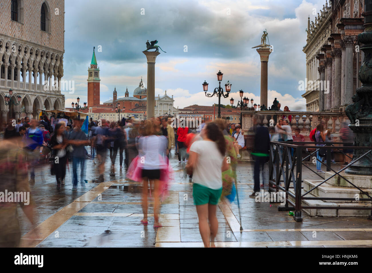 Tourists visit San Marco square in Venice.They take pictures and selfie and enjoy with the place.Venice attracts tourists from all over the world. Stock Photo