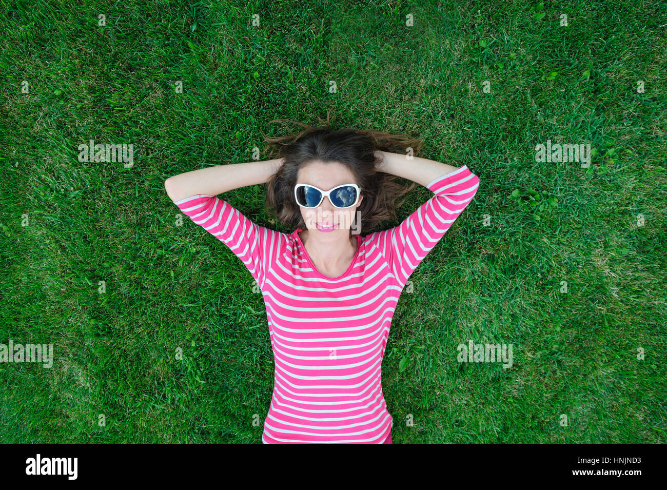beautiful young woman lying on the grass in the park Stock Photo - Alamy