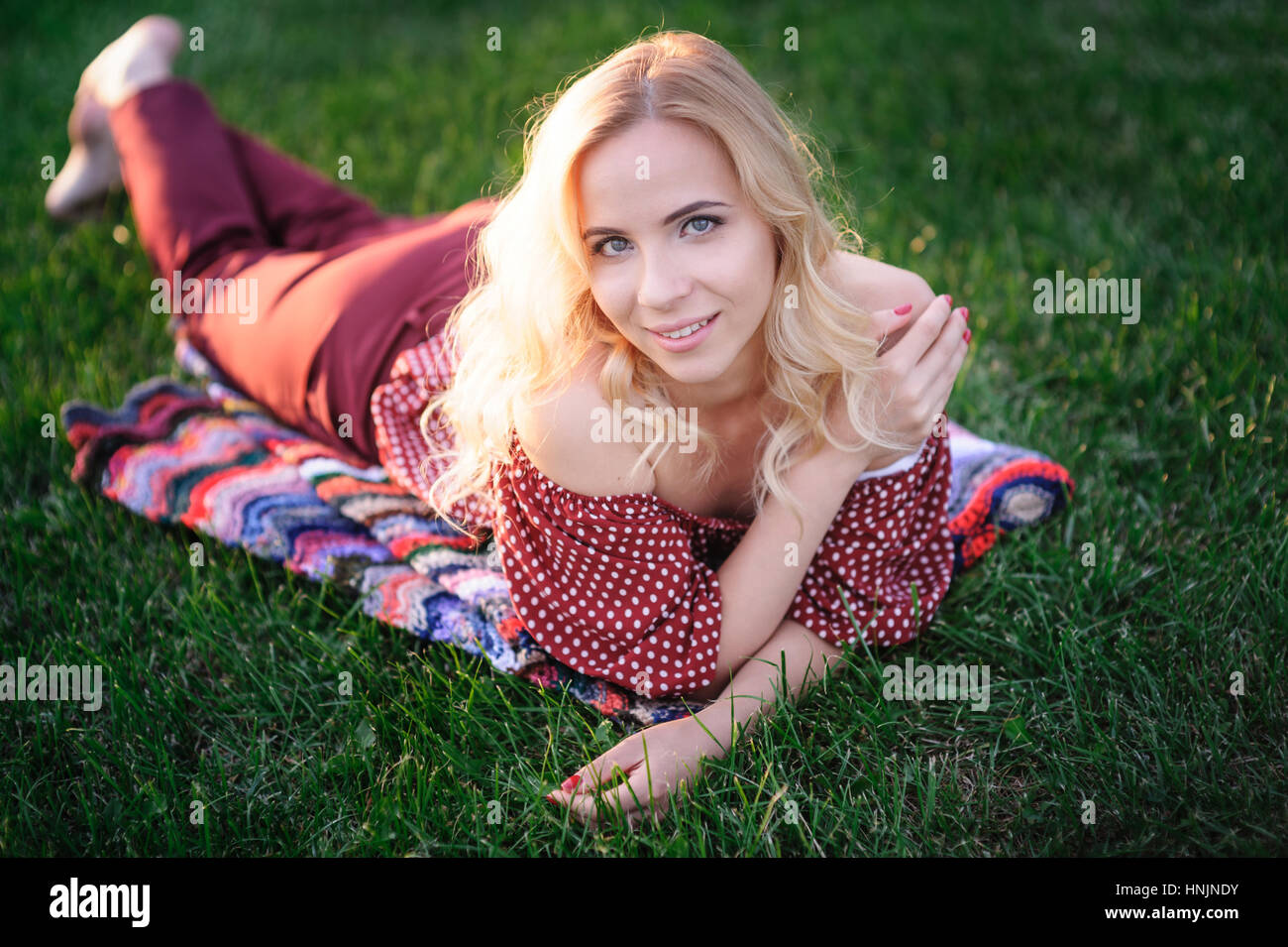 beautiful young woman lying on the grass in the park Stock Photo - Alamy