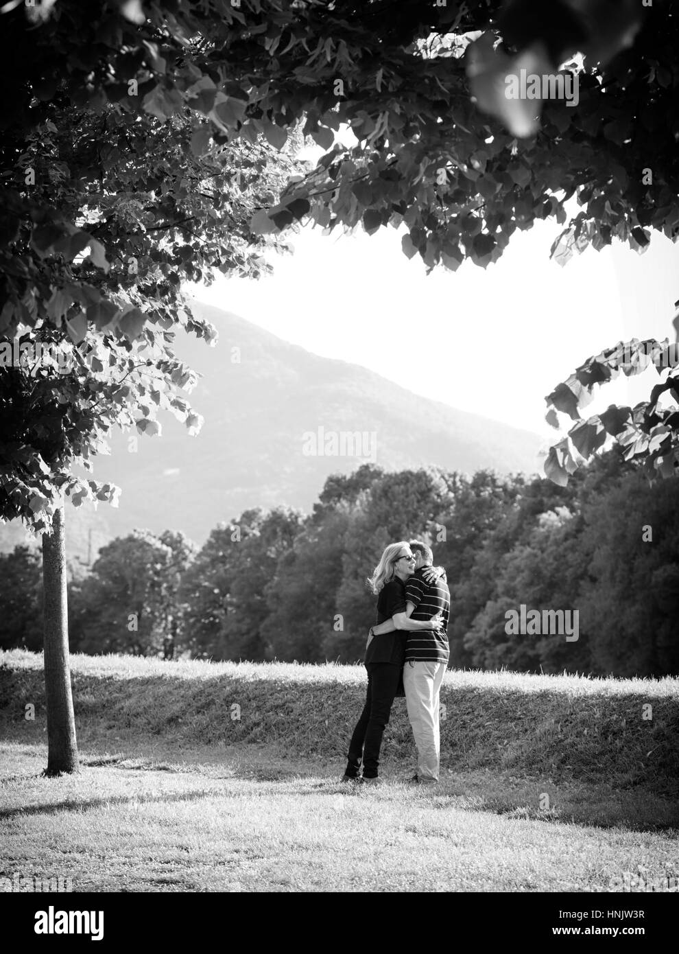 Middle-aged couple embracing in the gardens of the walls of Lucca, Italy. Stock Photo