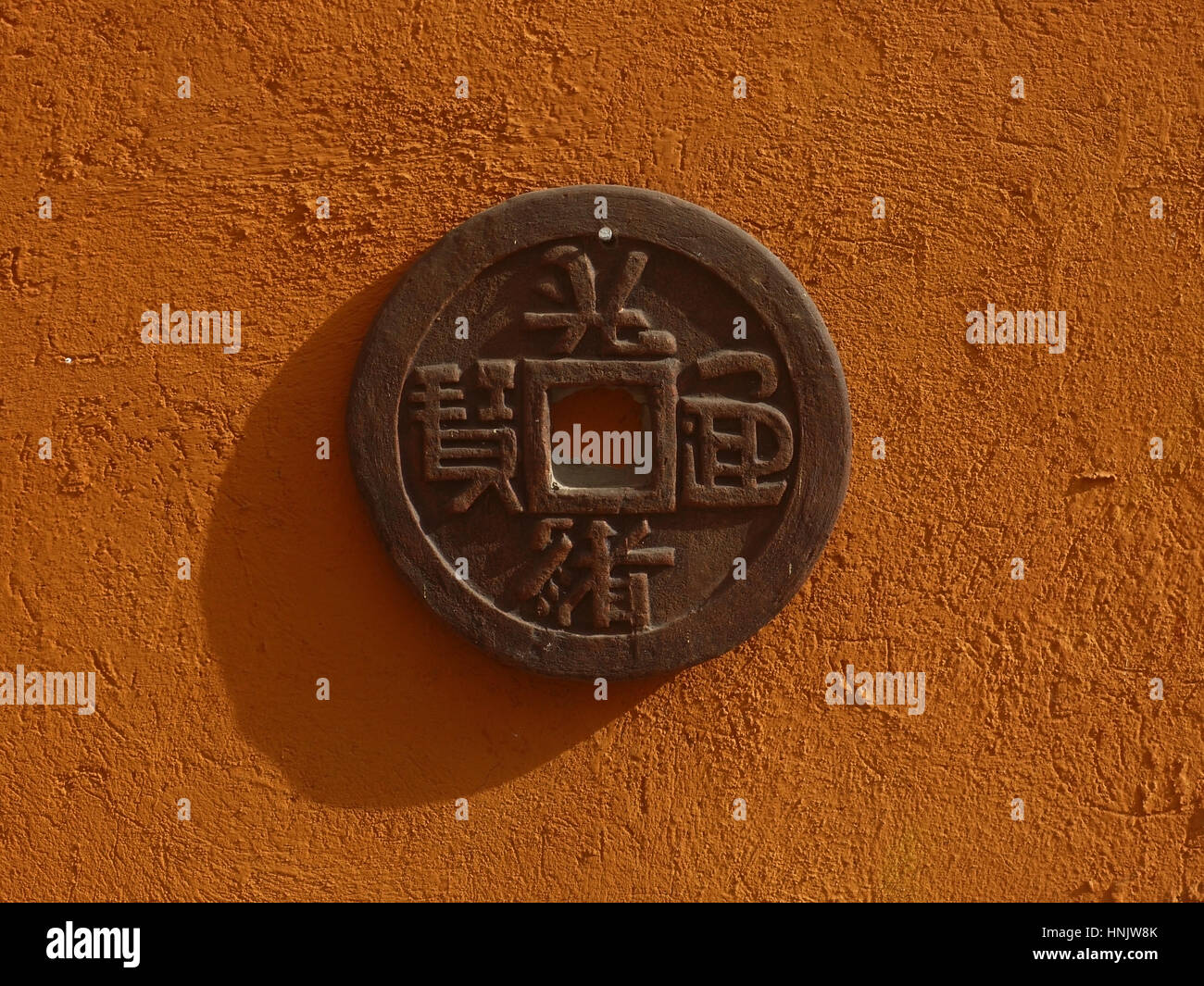 Stone Chinese coin on the wall. Bali, Indonesia Stock Photo