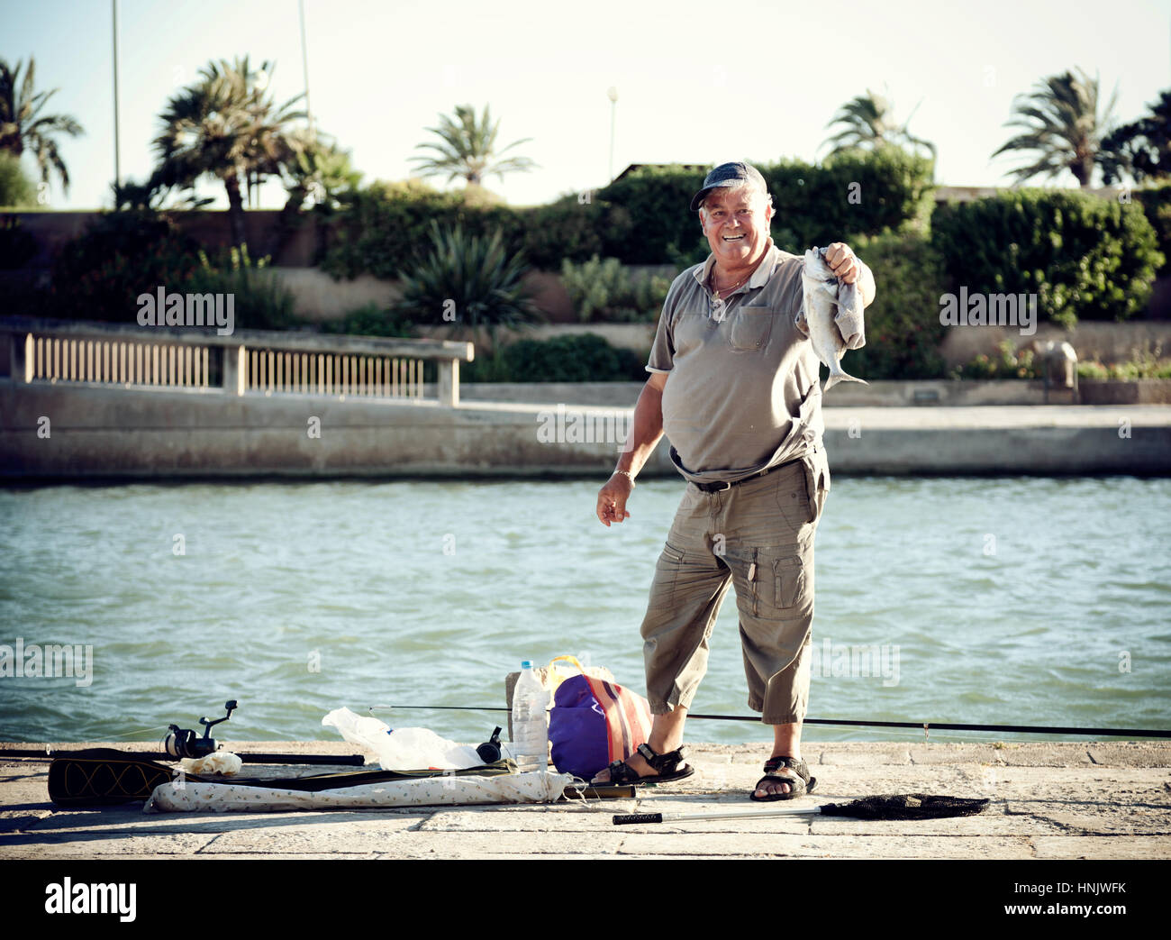 Man fishing in the artificial lake of Palma De Mallorca near the cathedral. Stock Photo