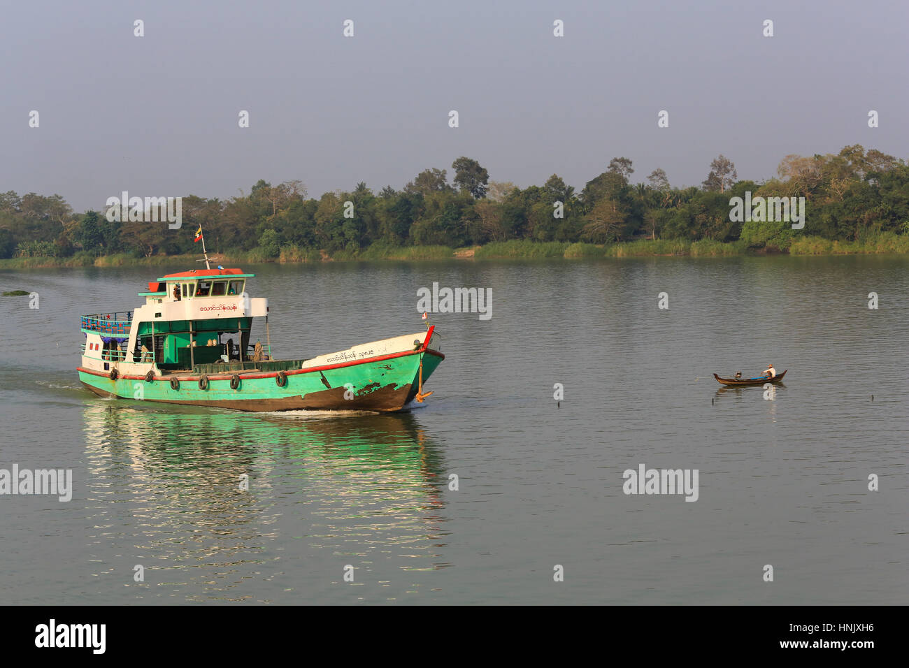 Riverboat crossing line of fish floats on the Irrawaddy River in Myanmar (Burma). Stock Photo