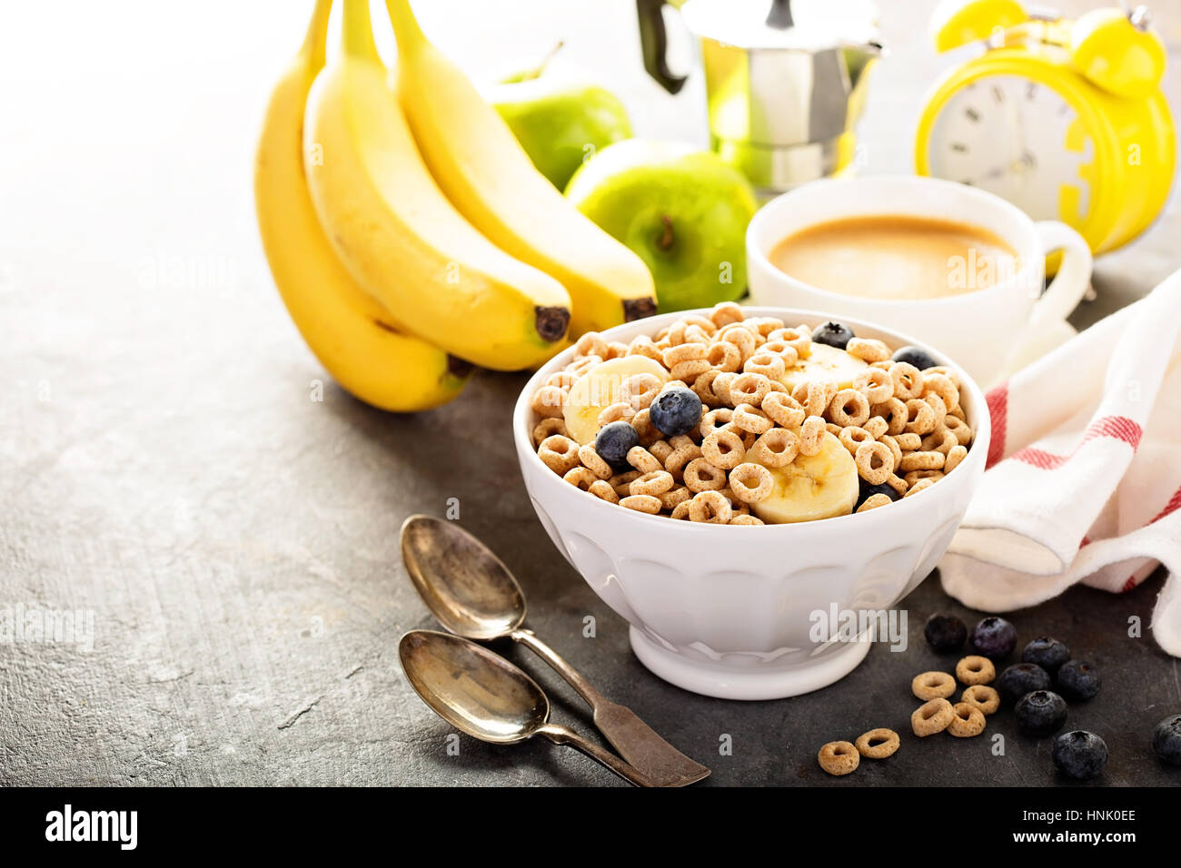 Healthy cold cereal with banana and blueberry in a white bowl, quick breakfast or snack for