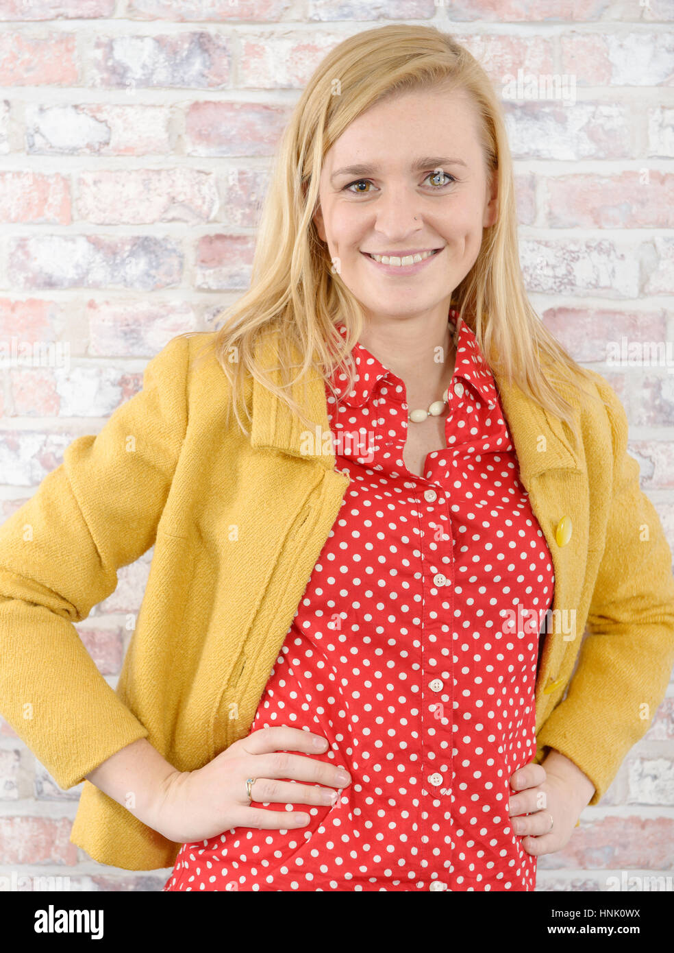 beautiful young blonde woman with a yellow jacket Stock Photo - Alamy
