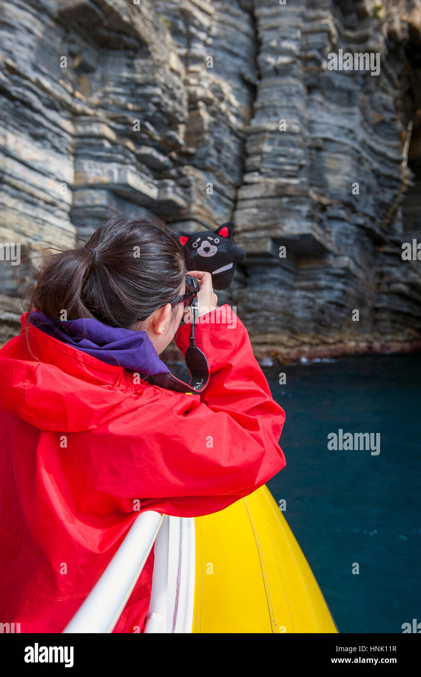 Chinese tourists taking selfies on Pennicott Wilderness Journey's cruise of the Tasman Peninsula's coastline in Tasmania. Stock Photo