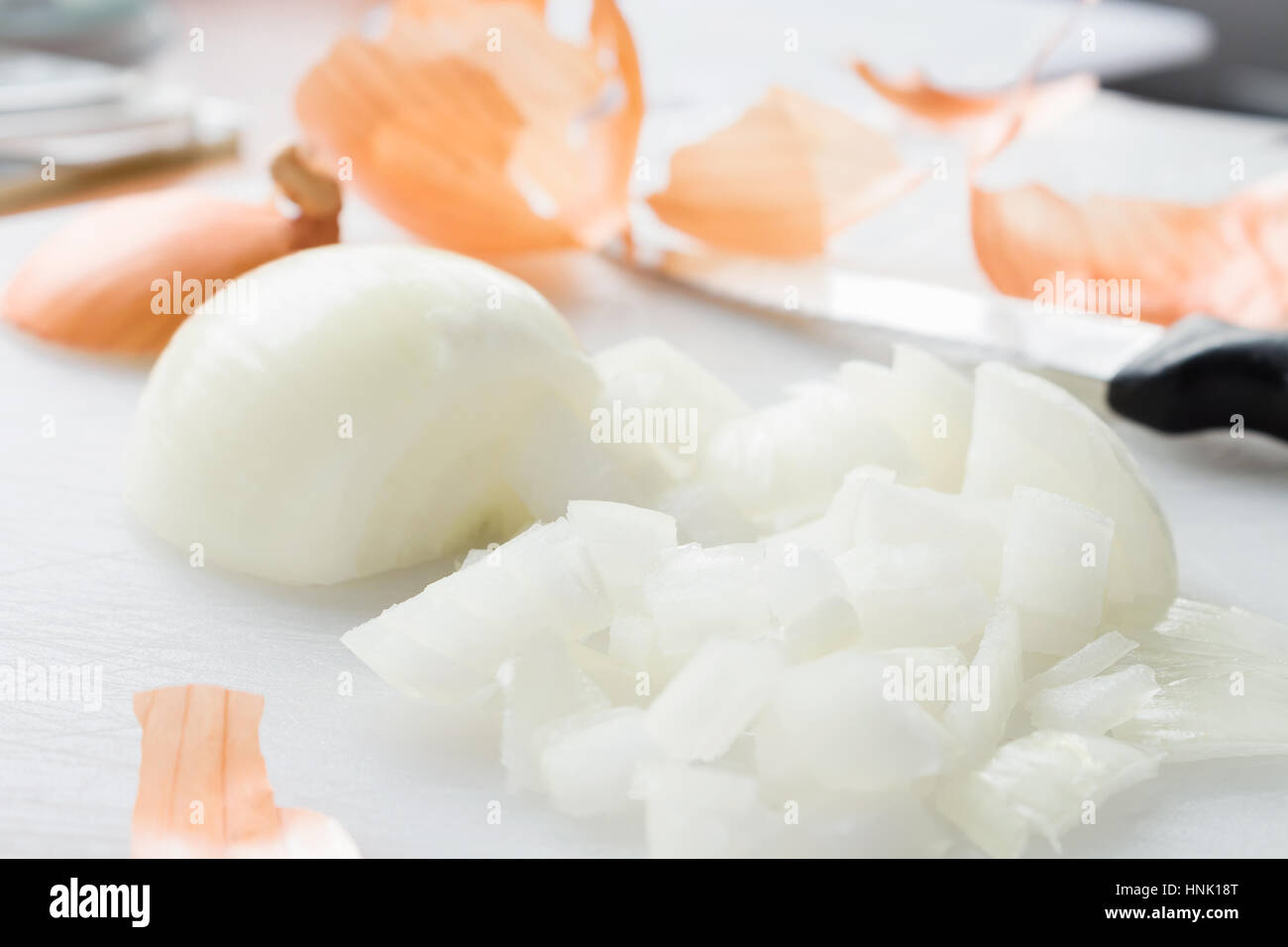 Yellow onion peeled and chopped on a white chopping board Stock Photo ...