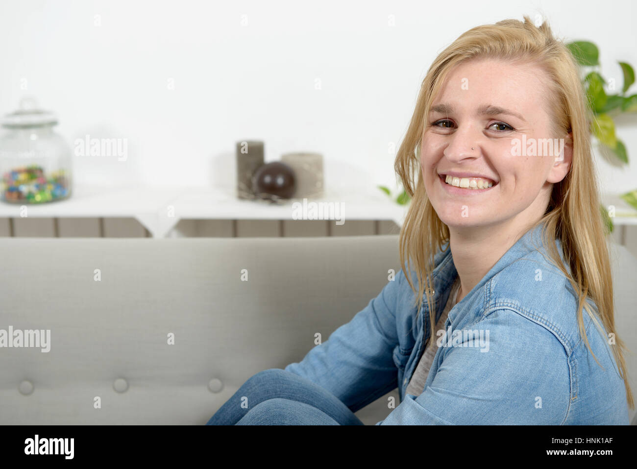 beautiful young blonde woman relaxing on sofa Stock Photo - Alamy