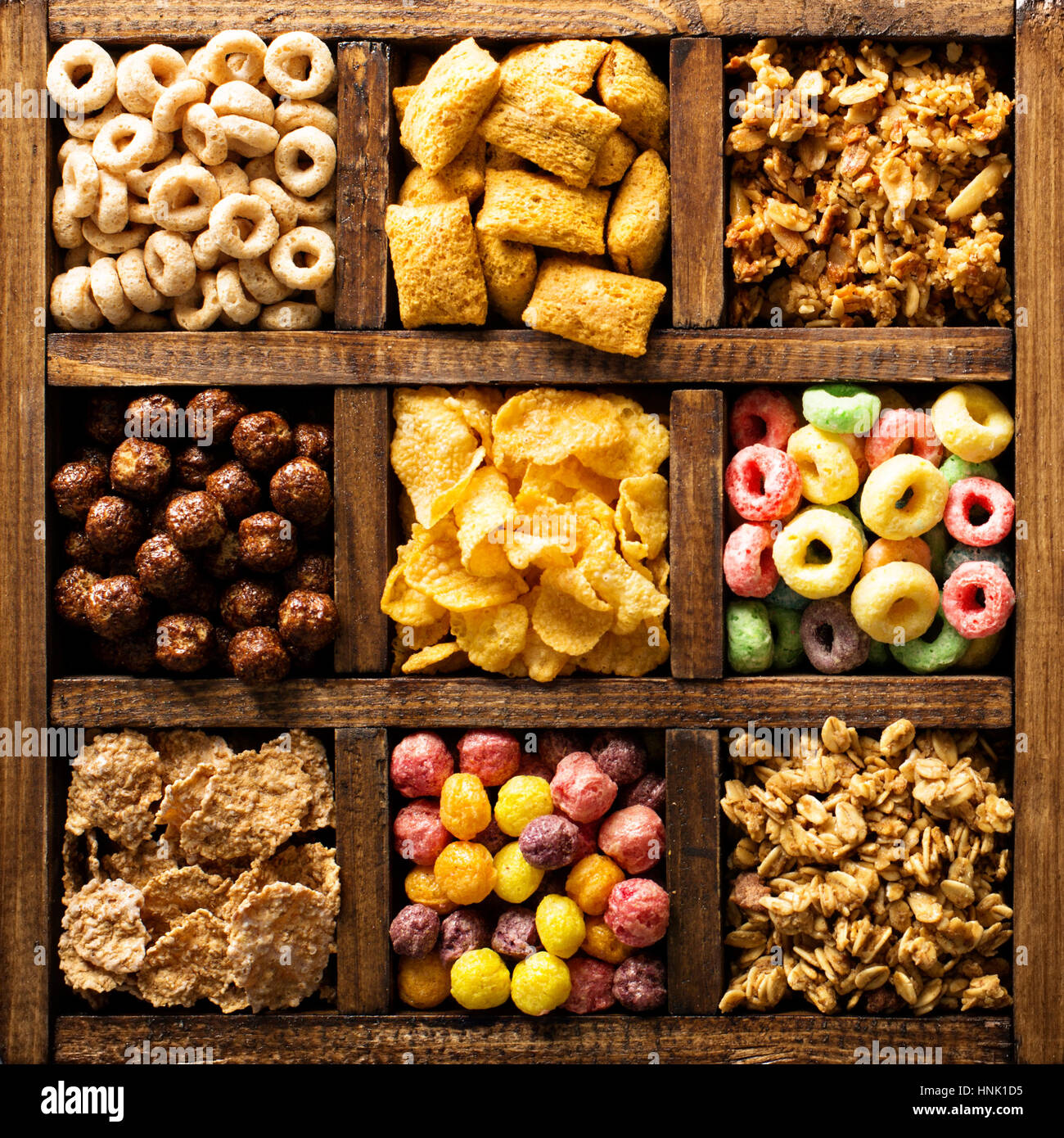 Variety of cold cereals in a wooden box, quick breakfast for kids overhead shot Stock Photo