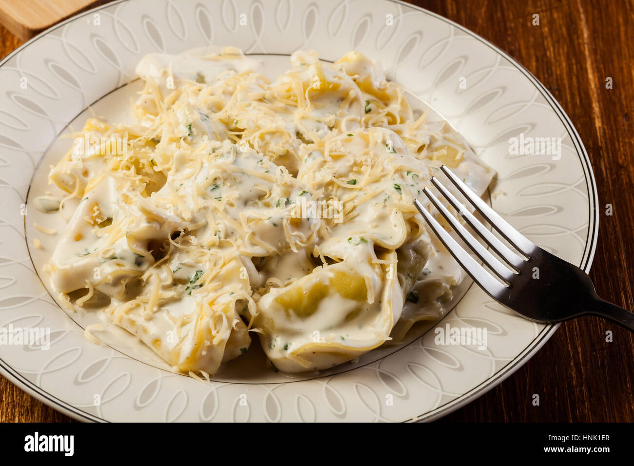 Italian tortellini in cream sauce with basil and parmesan cheese Stock