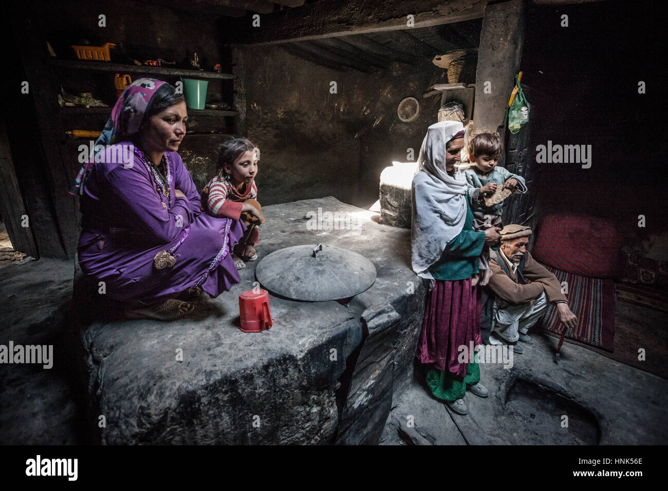 Afghanistan, Wakhan corridor, grandmother, grandfather and mother inside the house in the stone kitchen with children. Stock Photo