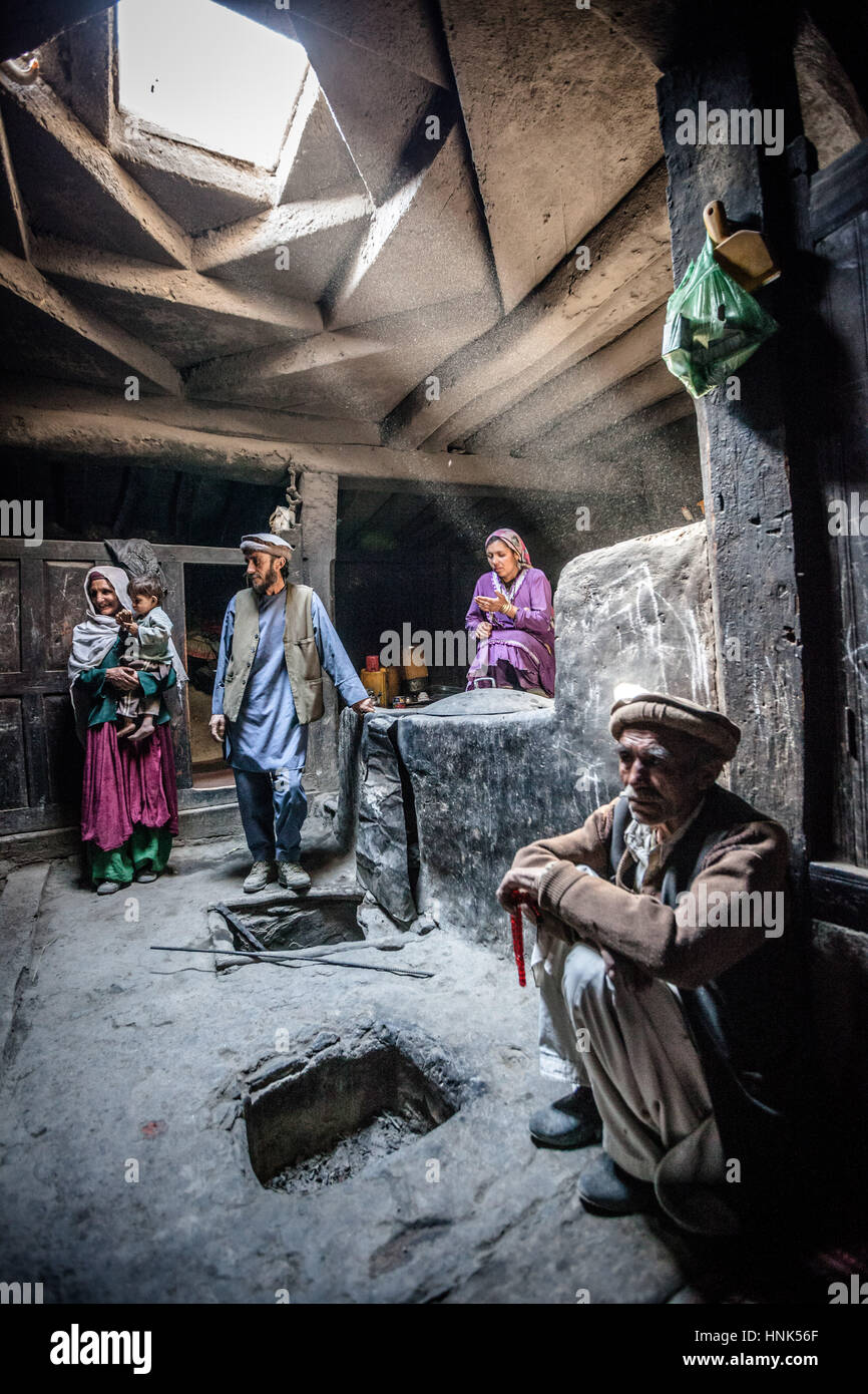 Afghanistan, Wakhan corridor, a family inside the house in the stone kitchen with children. Stock Photo