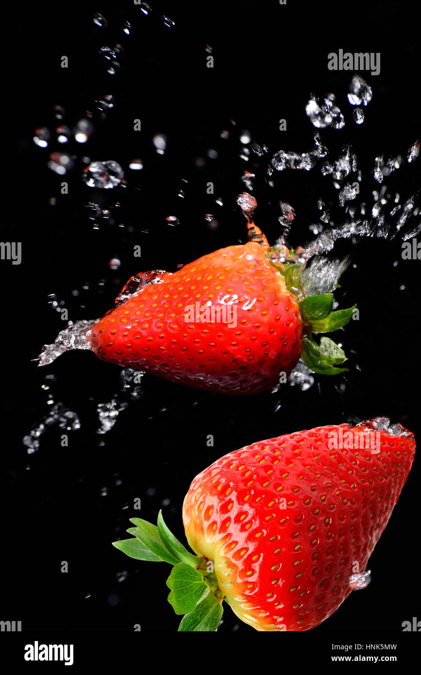 Strawberry in motion on a black background with splash of water Stock ...