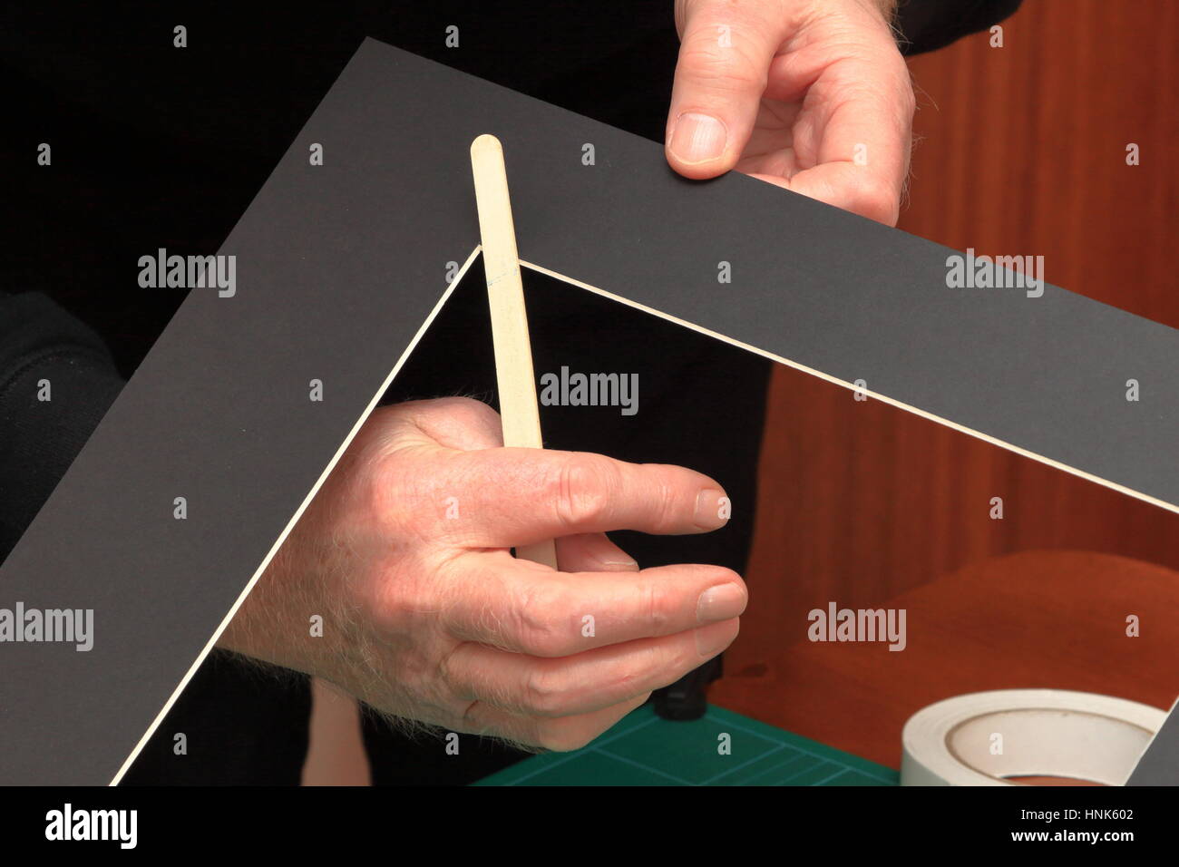 Using a common nail emery board to carefully tidy up small imperfections in the corners of a freshly cut picture mount Stock Photo