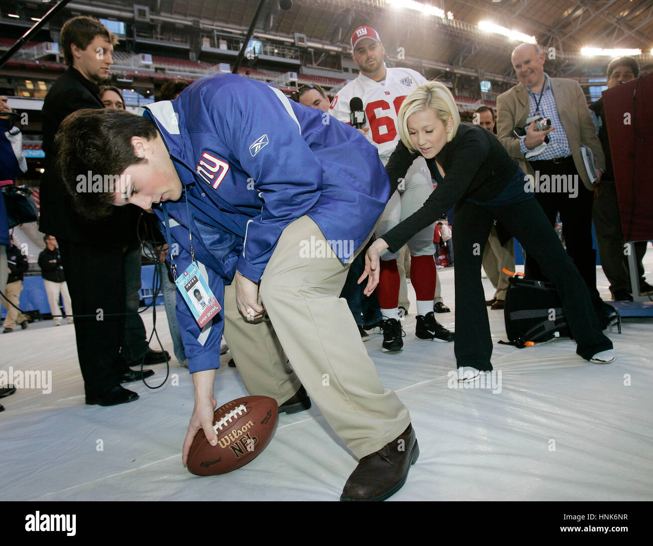 Giants center Shaun O'Hara (60) teaches former American Idol finalist Kellie Pickler how to receive a snap by Craig Falicon, left, during Media Day for Super Bowl XLII  at the University of Phoenix Stadium in Glendale, AZ, on Jan. 29, 2008.  Photo by Francis Specker Stock Photo