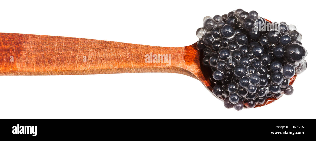 salty black dyed caviare of halibut fish in wood spoon isolated on white background Stock Photo