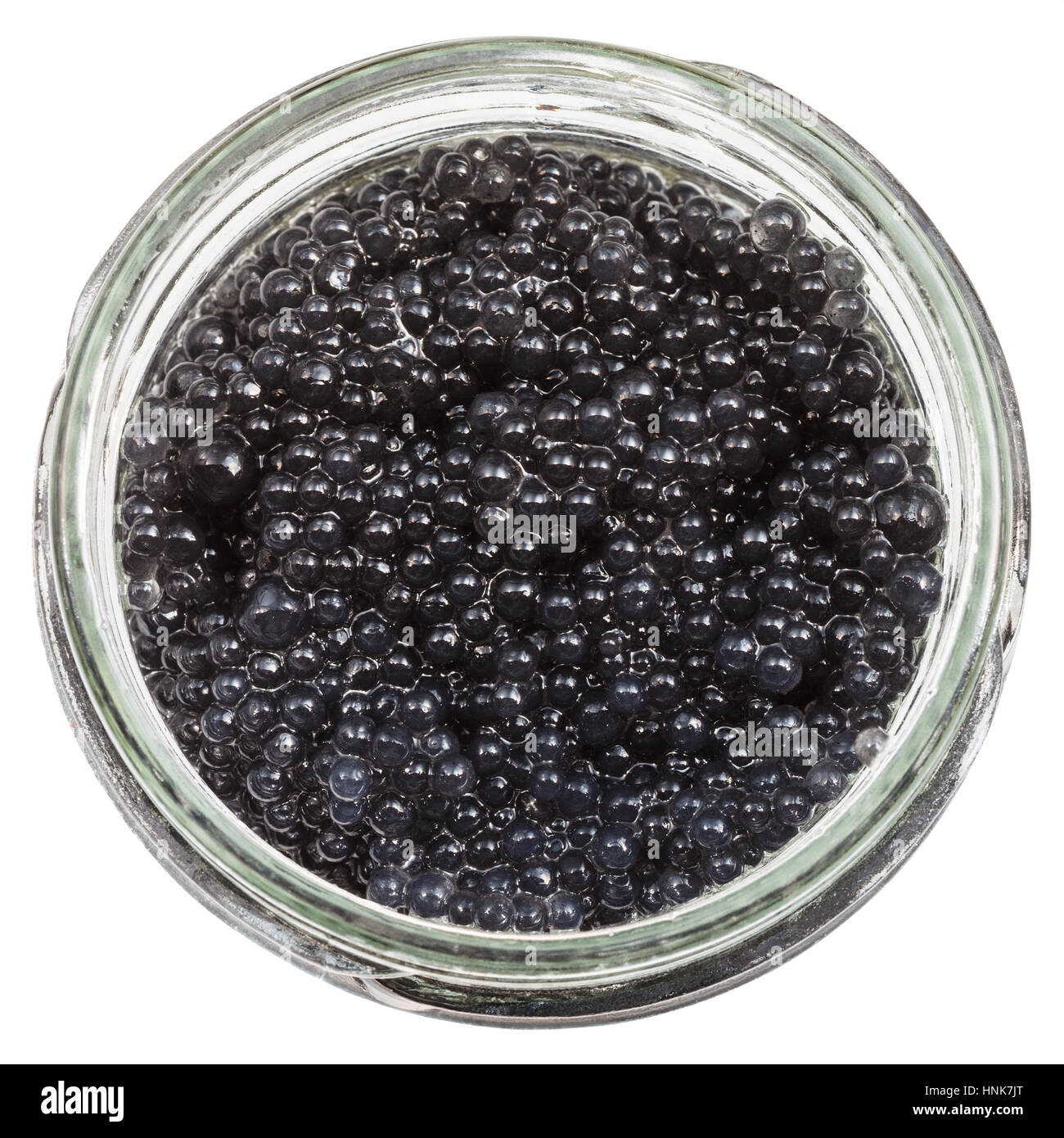 top view of black coloured pickled caviar of halibut fish in glass jar isolated on white background Stock Photo
