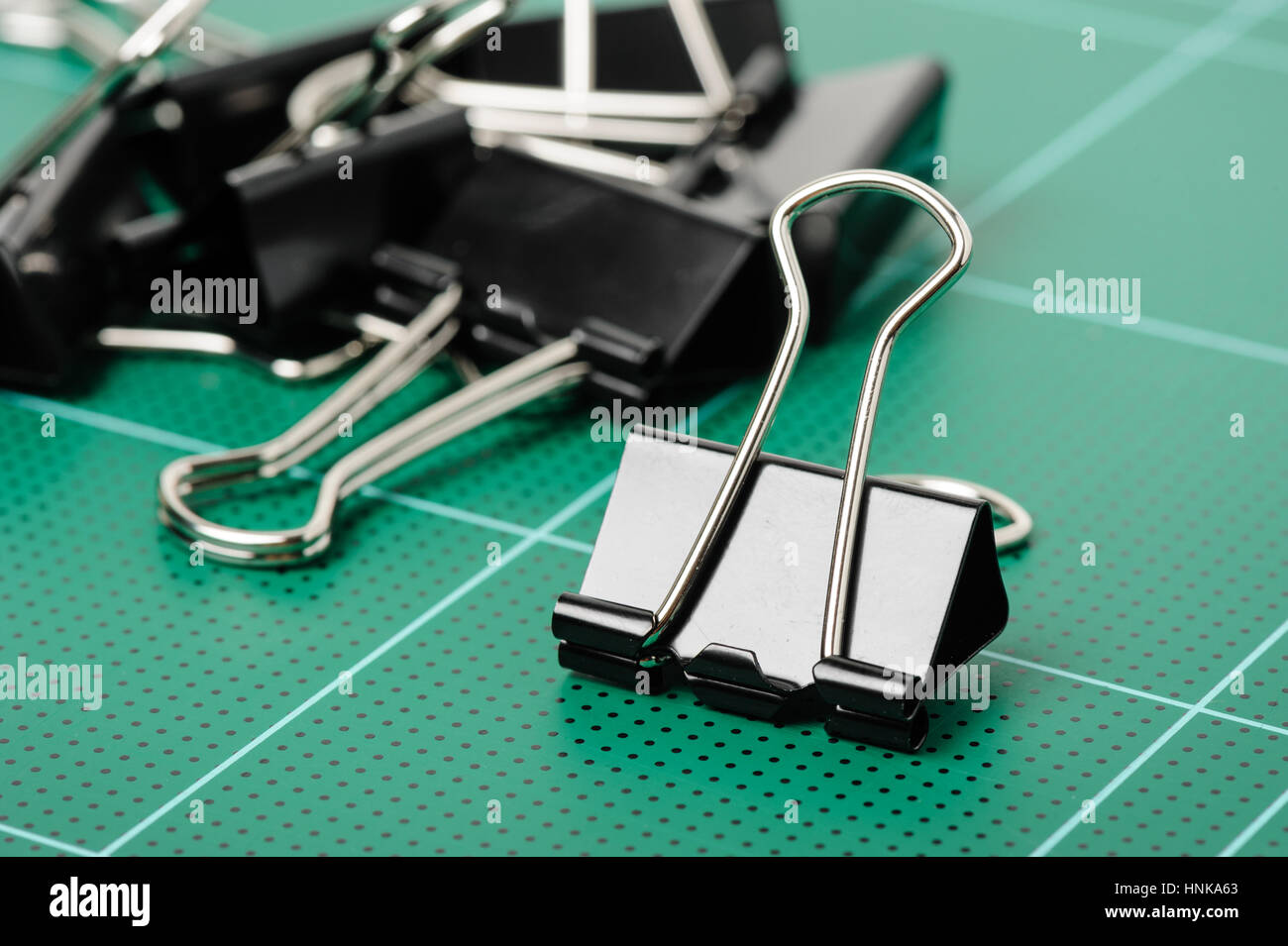 black binder clips isolated on cutting mat Stock Photo Alamy