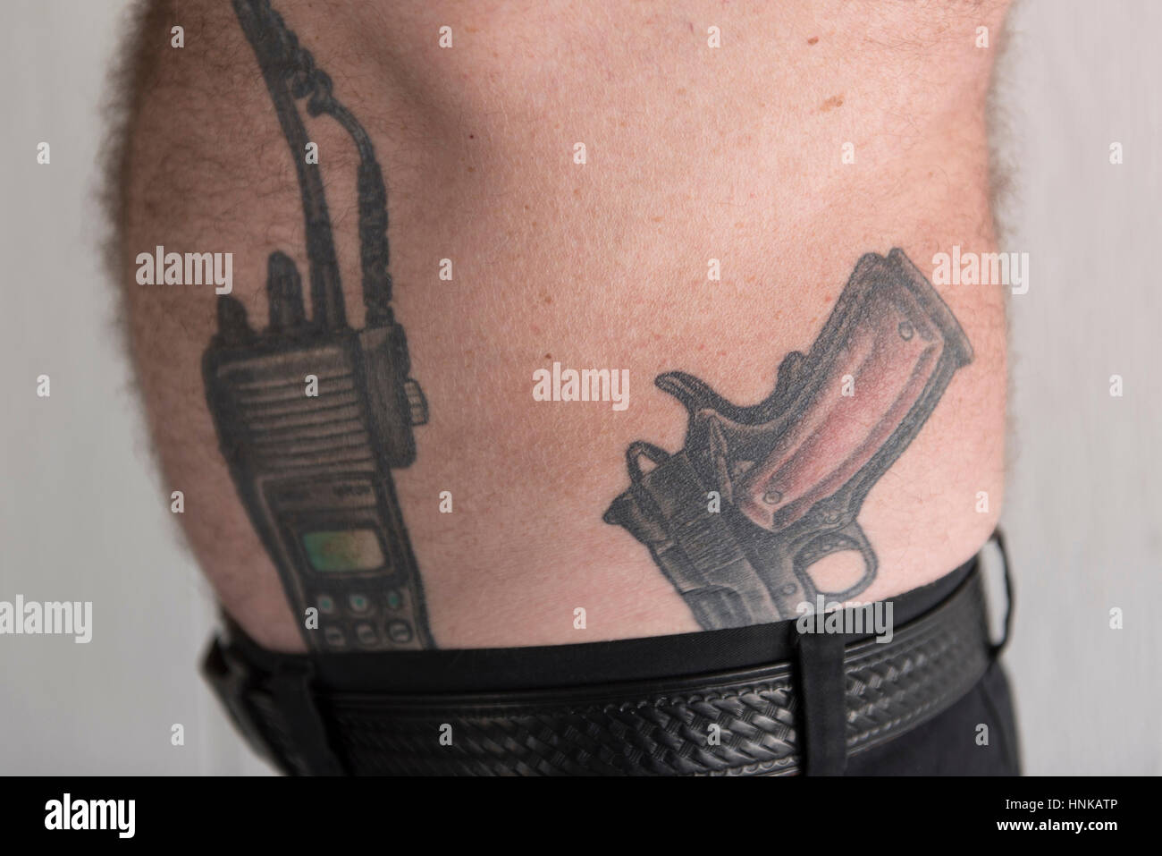 Retired police officer and Nevada Highway Patrol Trooper Brad Carson shows tattoos of a police radio and a Guncrafter Industries .50 caliber handgun. Stock Photo