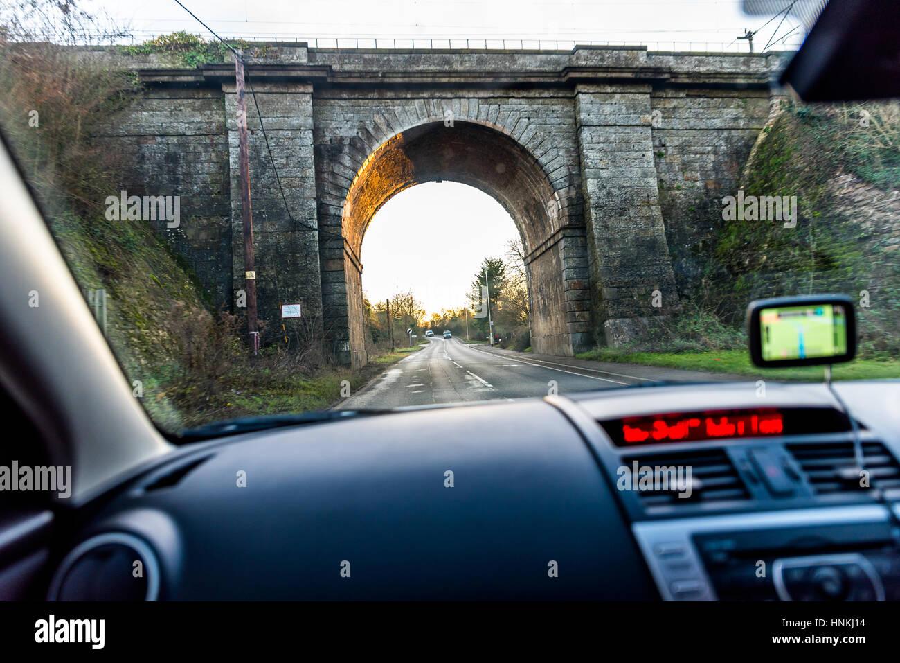 Car interior view of traveling below railroad bridge in UK Stock Photo
