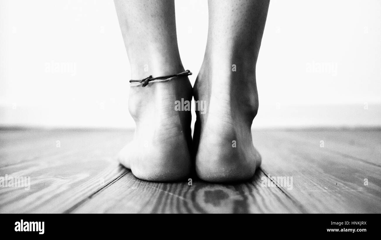 Womans heels with a bracelet standing on wooden floor Stock Photo
