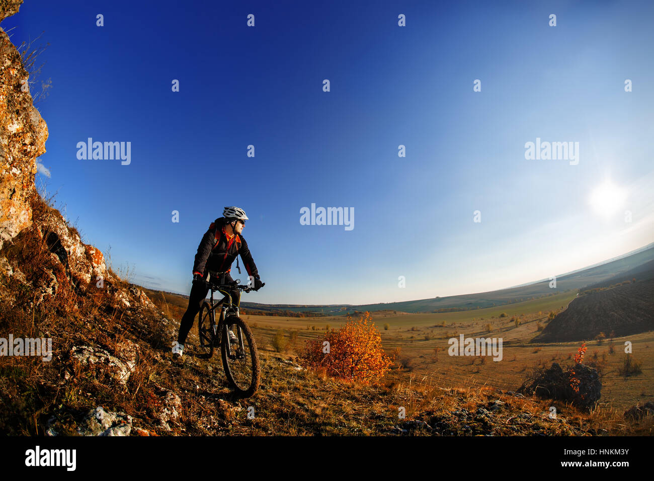 Wide angle view of a cyclist riding a bike on a nature trail in the ...