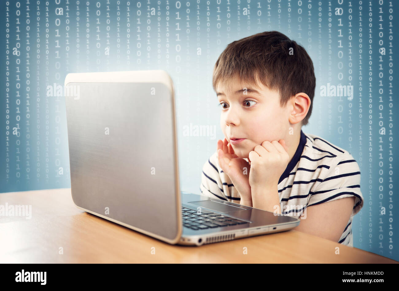 seven years old child sitting with a laptop Stock Photo