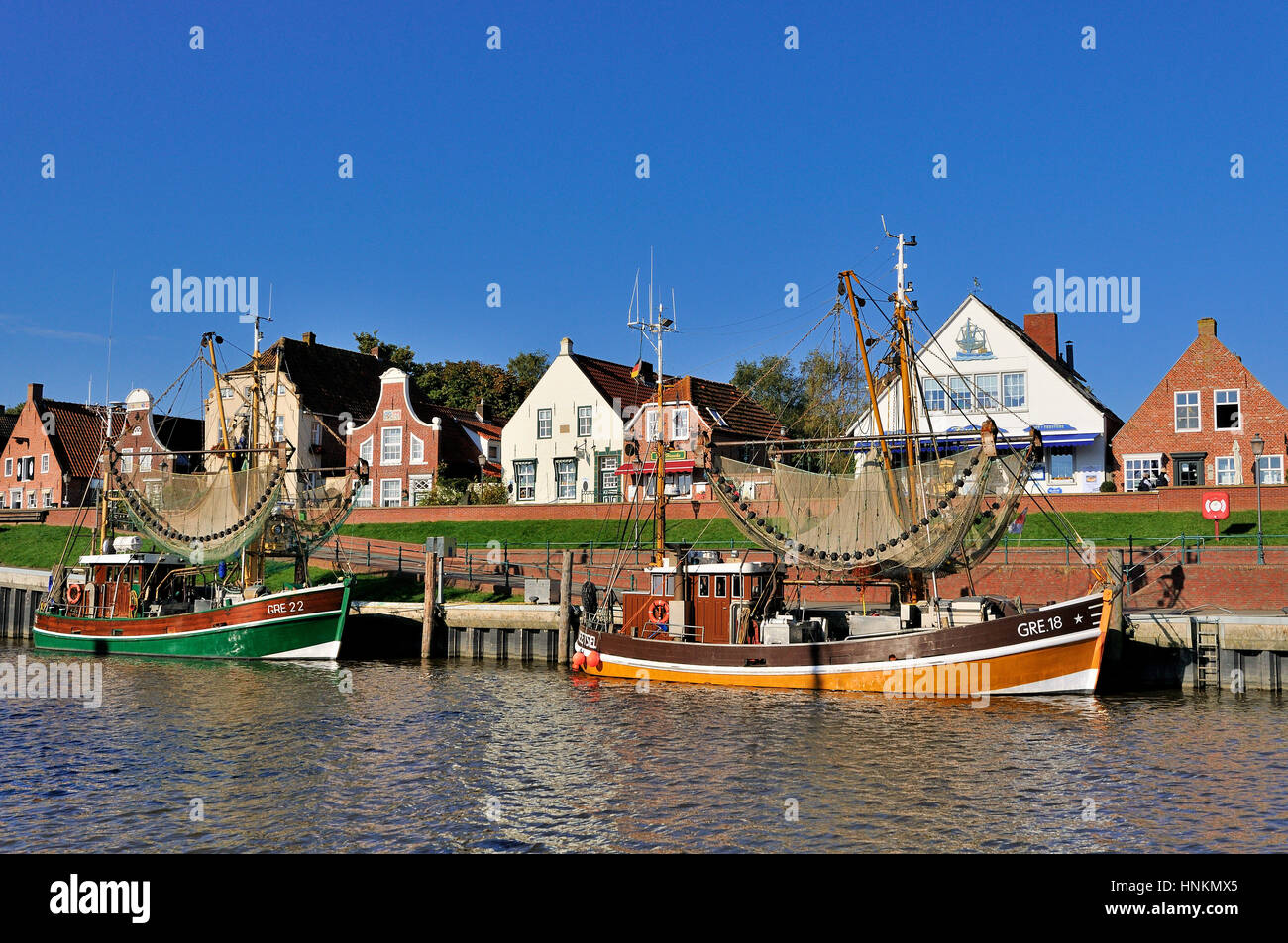 Crab cutters in the harbor, in front of historical buildings, Greetsiel, Lower Saxony, Germany Stock Photo