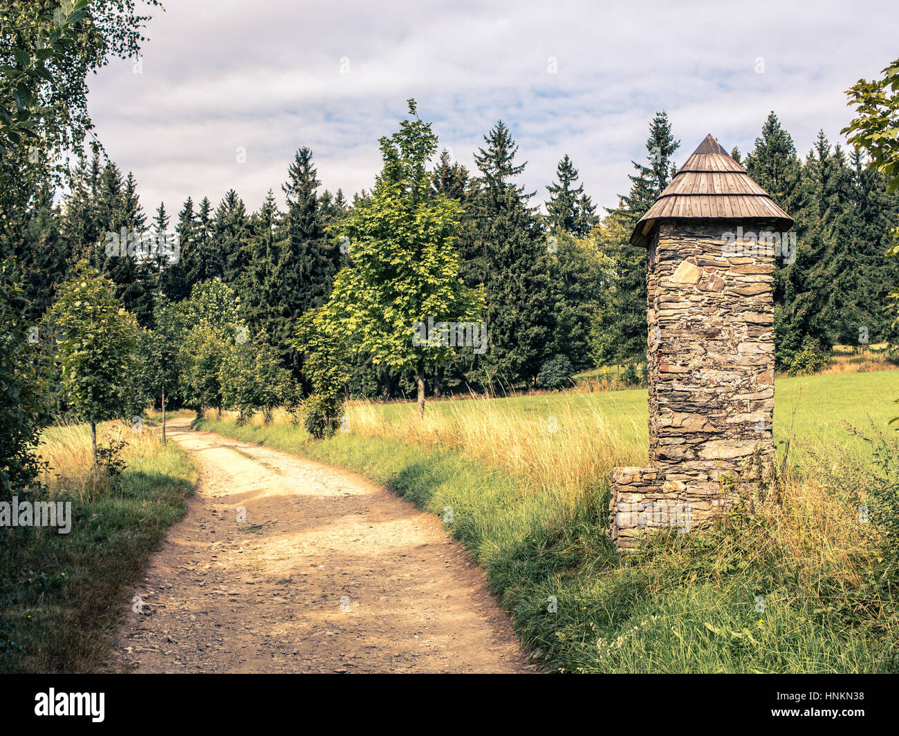 Stone chapel on pathway in summer countryside Stock Photo