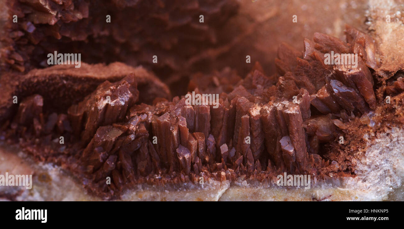 Calcite crystal grown inside a rock cavity. Brown colour from contamination and infiltration of red dirt. Serra da Arrabida, Portugal. Stock Photo