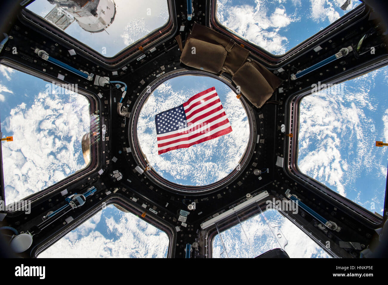 American flag is visible in the windows of the cupola aboard the International Space Station Stock Photo