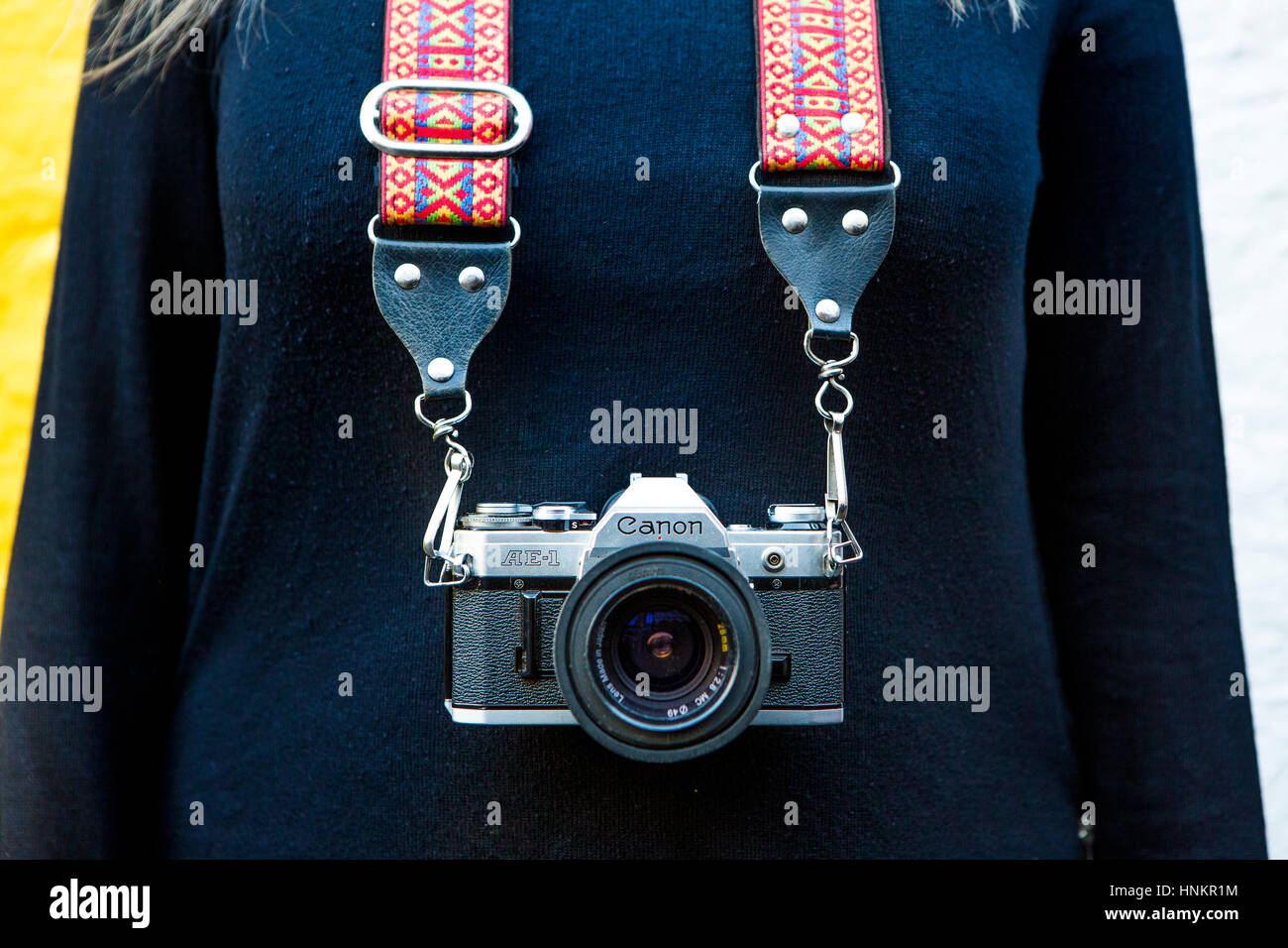 Vintage Canon camera on strap around girls neck, film photography. Stock Photo