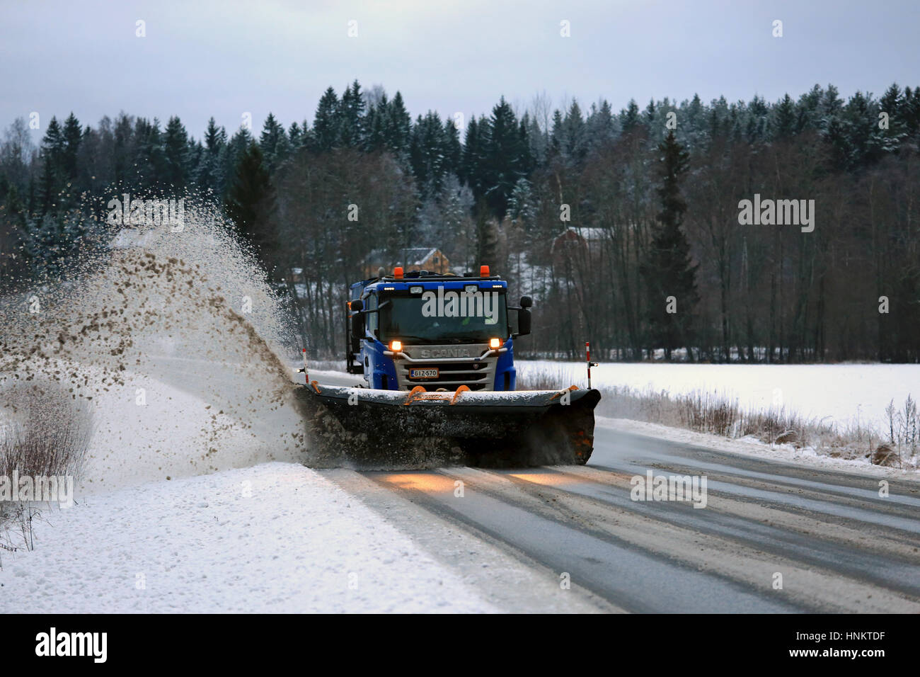 SALO, FINLAND - JANUARY 14: Scania truck equipped with snowplow removes snow and sleet from highway in South of Finland on a cloudy aftermoon in winte Stock Photo