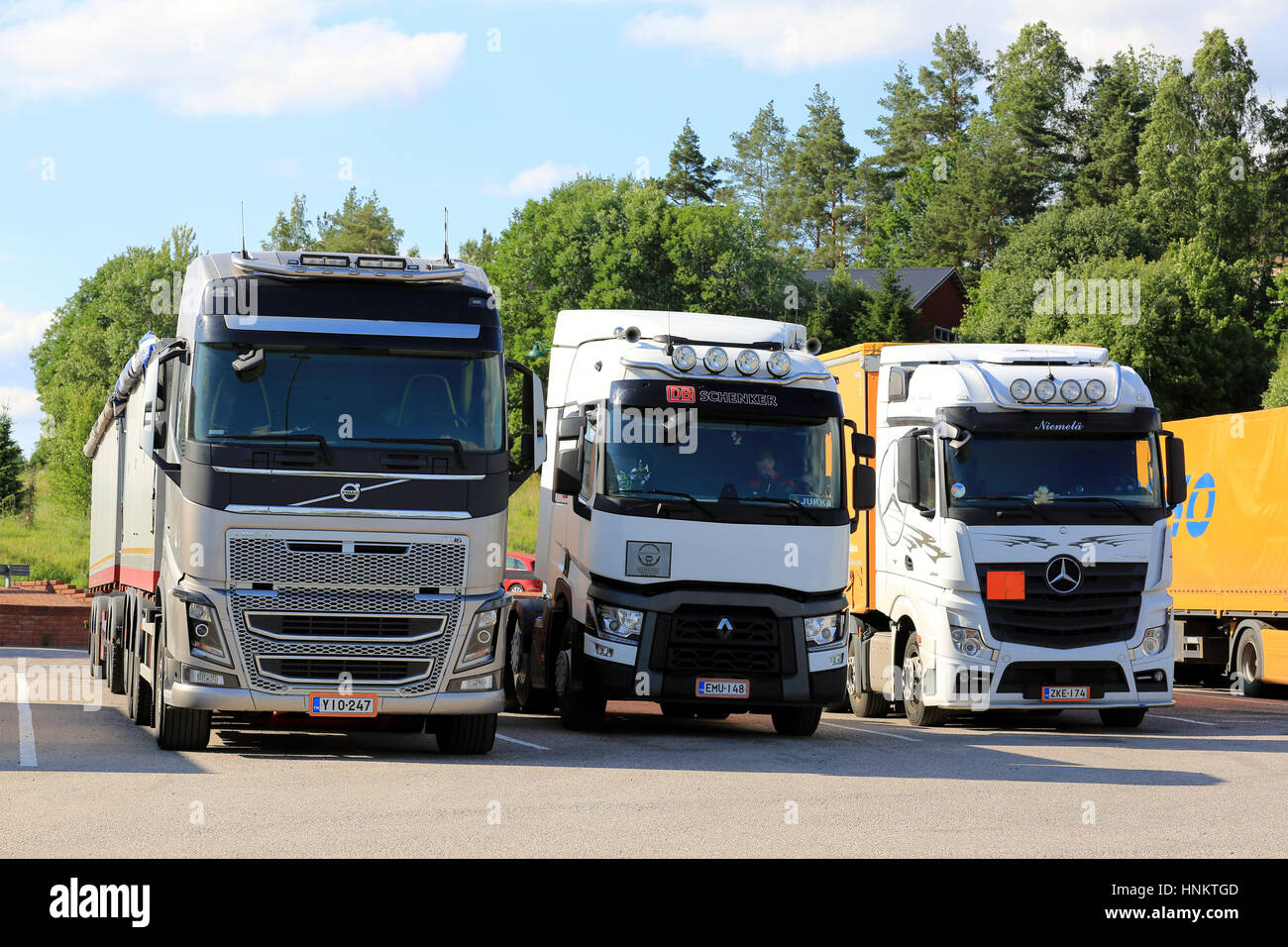 SALO, FINLAND - JULY 1, 2016: Modern Volvo FH, Renault Trucks T and Mercedes-Benz Actros heavy goods vehicles parked at a truck stop yard on beautiful Stock Photo