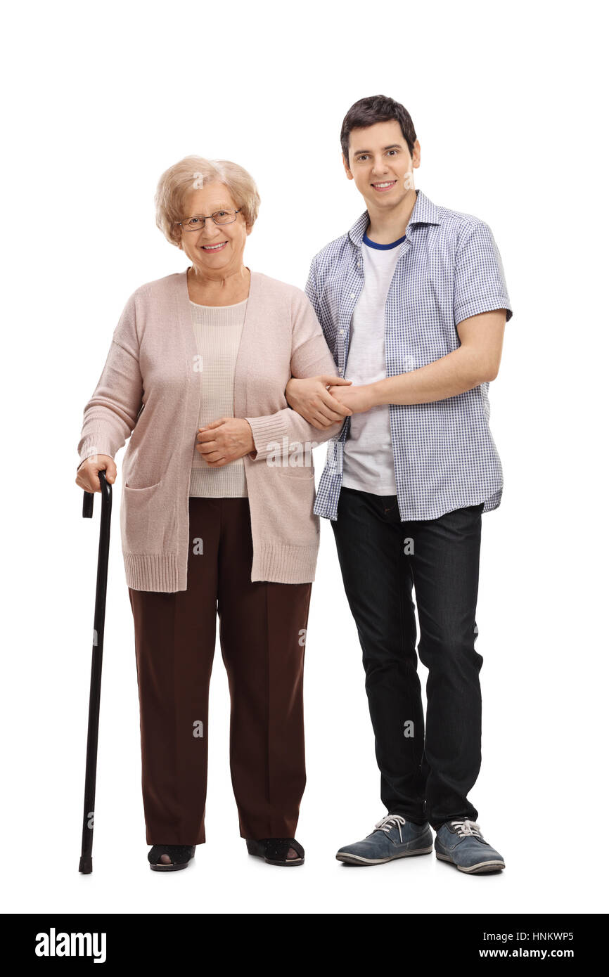 Full length portrait of an elderly lady with a walking cane and a young man helping her isolated on white background Stock Photo