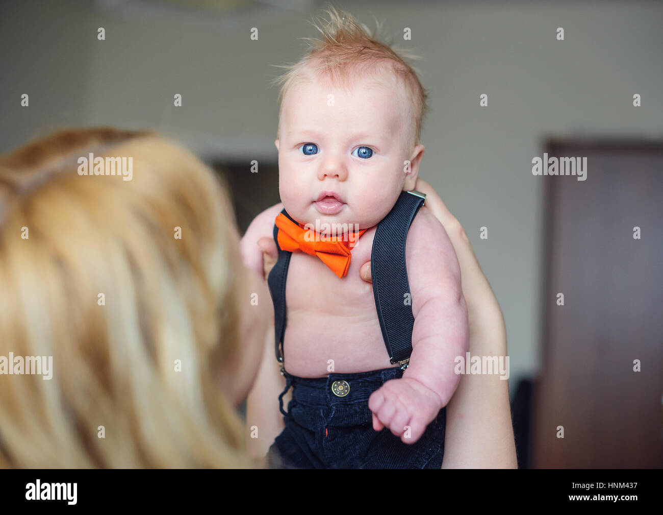 Mom holding the baby in her arms and looks at him Stock Photo