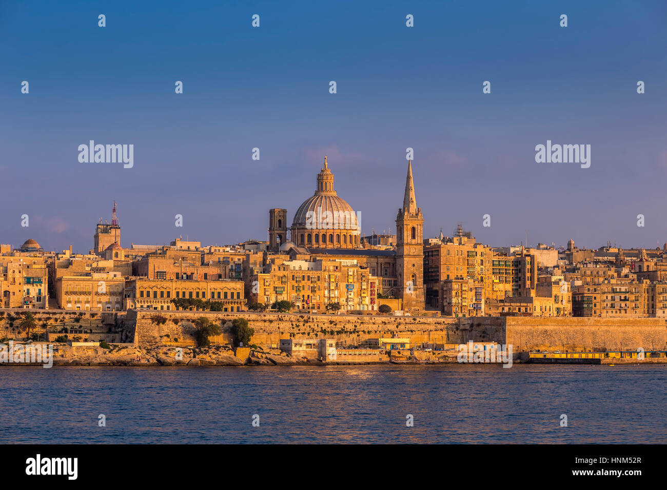 Valletta, Malta - The famous St.Paul's Cathedral and the ancient city of Valletta at sunset with clear blue sky Stock Photo