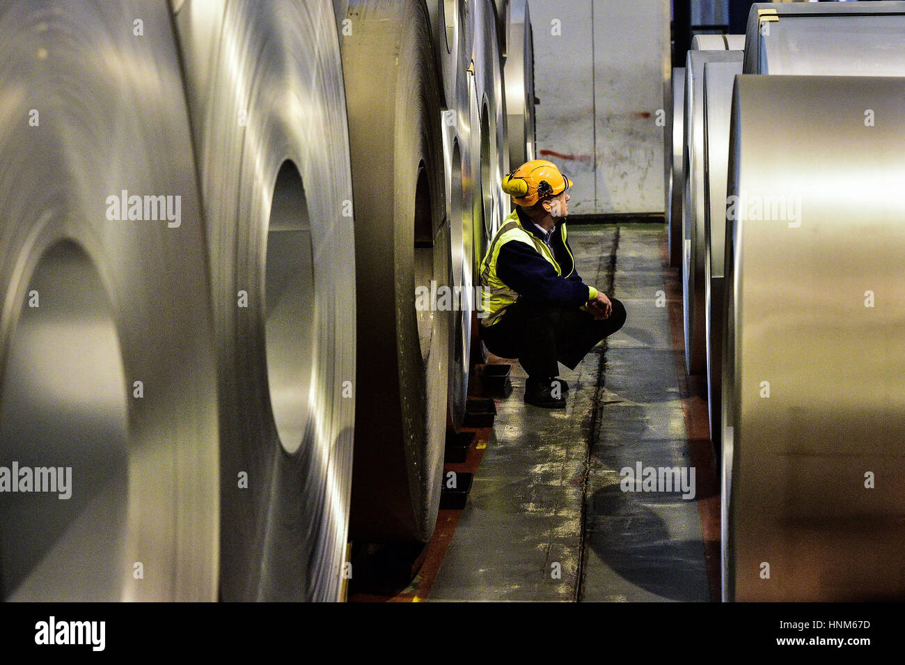 A steel worker inspects rolls of steel, which will be used by a high-tech robotic welding line as it is unveiled at the automotive service centre at Tata Steel's Wednesbury site in Willenhall, Wolverhampton. Stock Photo