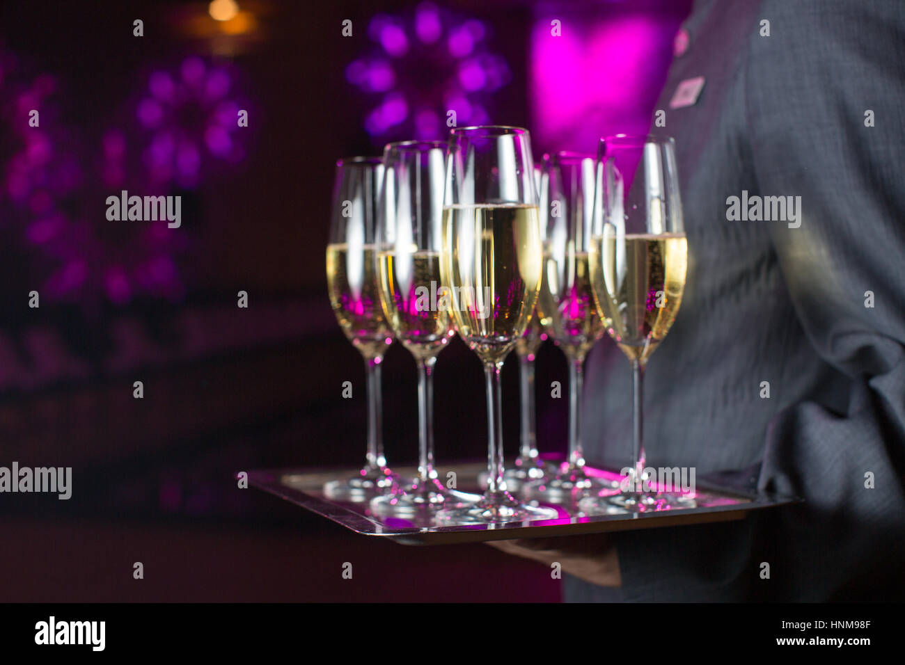Waiter serving champagne on a tray Stock Photo