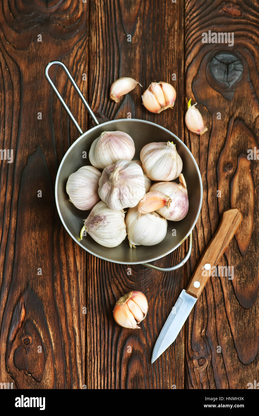 garlic in metal bowl and on a table Stock Photo - Alamy