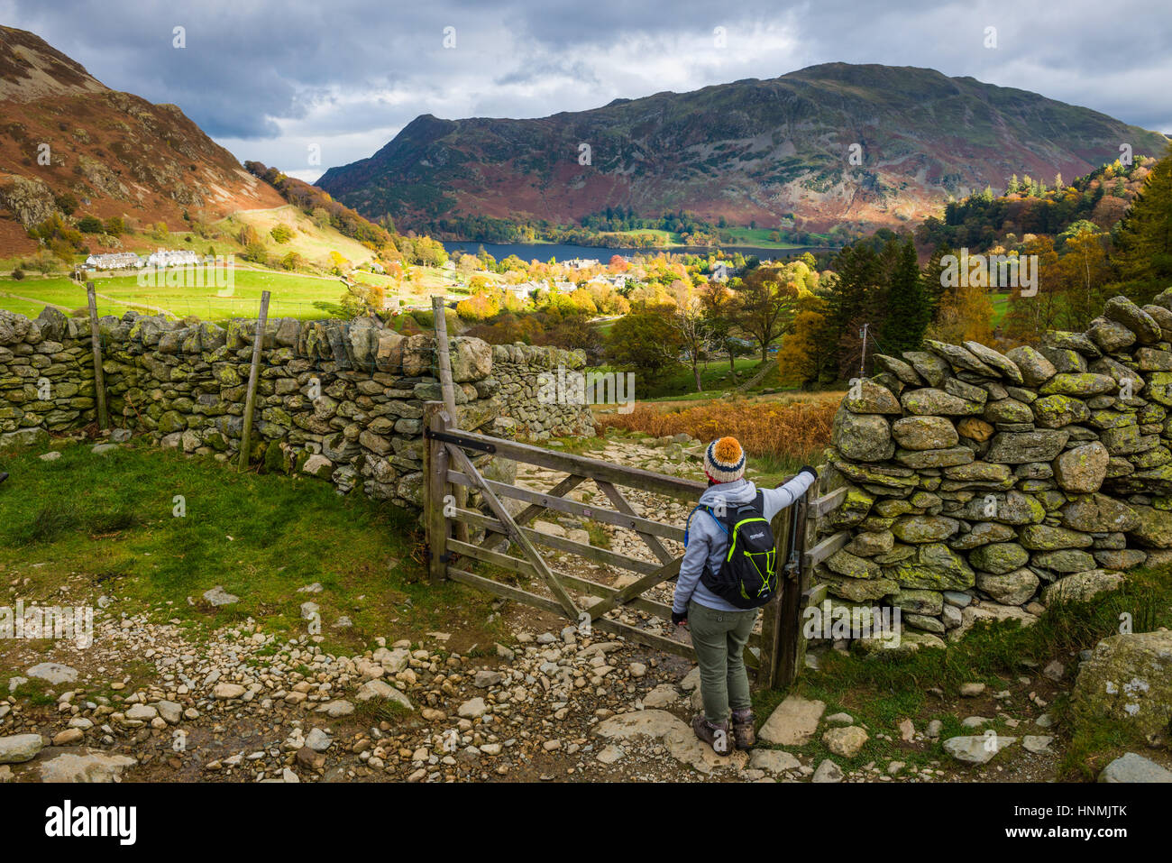 A young woman takes in the view over Glenridding and Ullswater. Lake District National Park, Cumbria, England. Stock Photo
