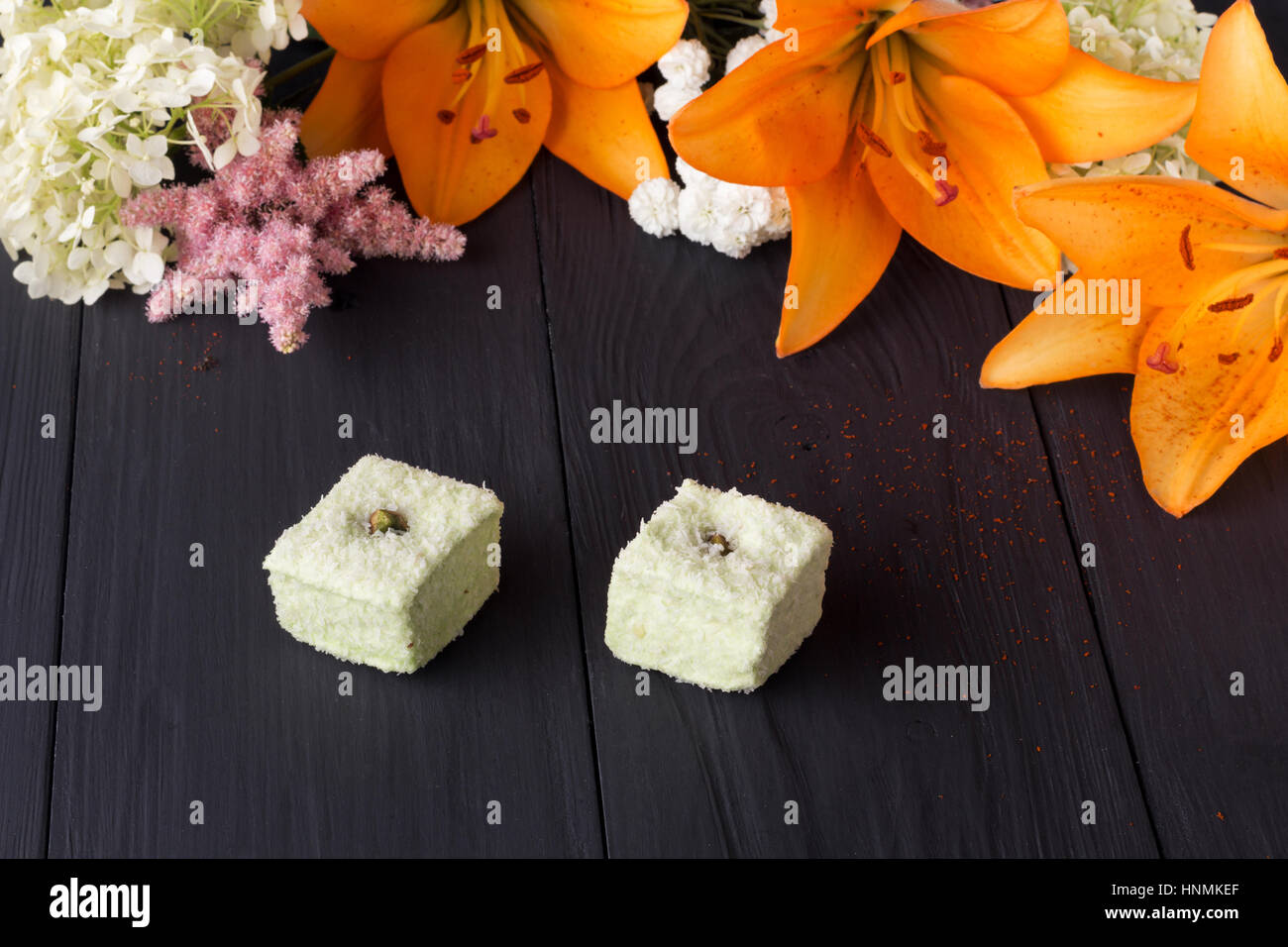 orange lily and candies on black boards Stock Photo