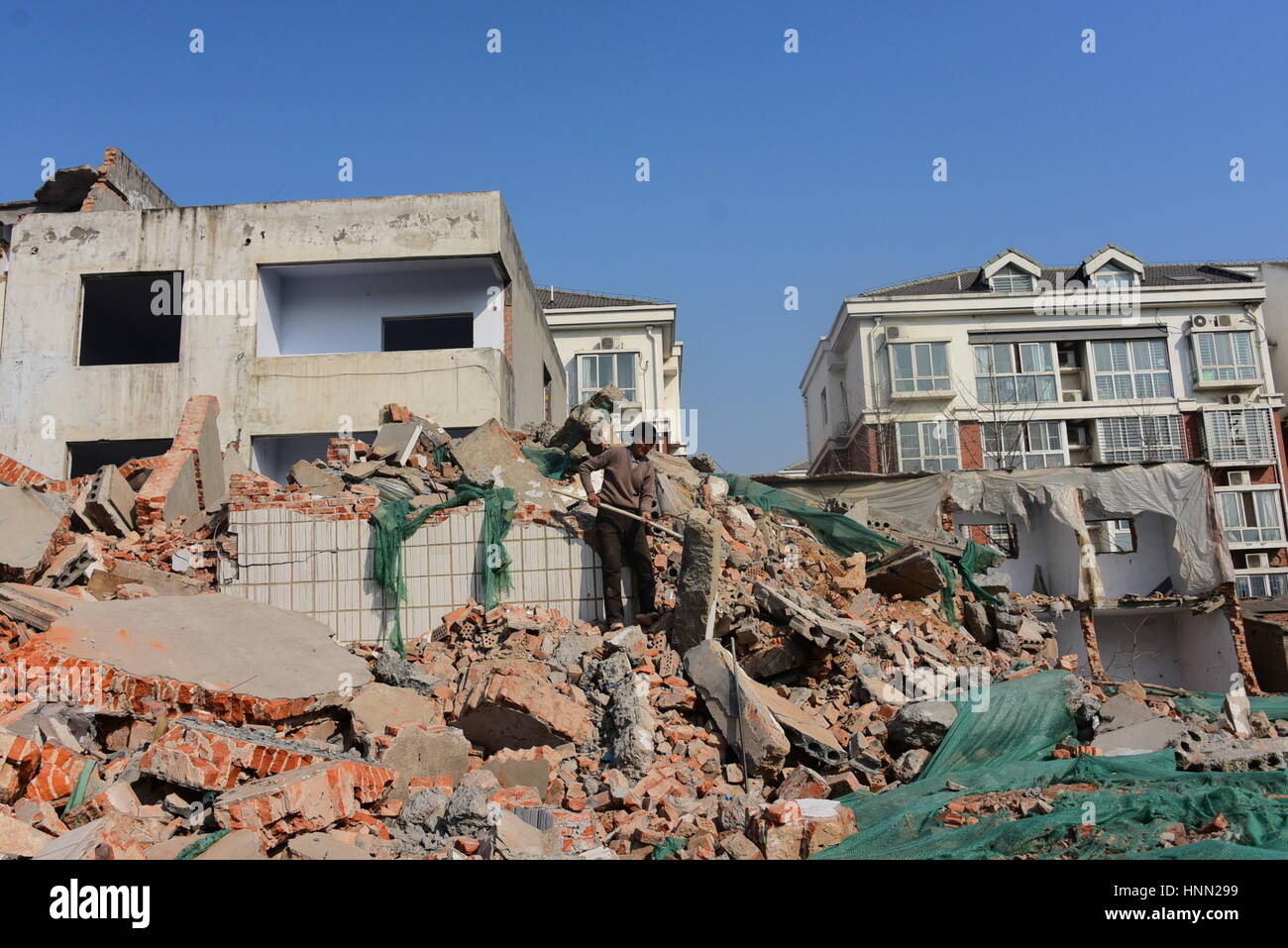 Zhengzh, Zhengzh, China. 15th Feb, 2017. Zhangzhou, CHINA-February 15 2017: (EDITORIAL USE ONLY. CHINA OUT) .A migrant worker searches concrete reinforcing bars at the ruins of construction sites in Zhengzhou, capital of central China's Henan Province, February 15th, 2017. Some migrant workers pick concrete at ruins and smash irons out of the concretes, trying to sell the irons. However, there aren't so many irons in the concrete, and they can only earn less than 10 yuan (US$1.5) every day by smashing irons out of concrete. Credit: SIPA Asia/ZUMA Wire/Alamy Live News Stock Photo