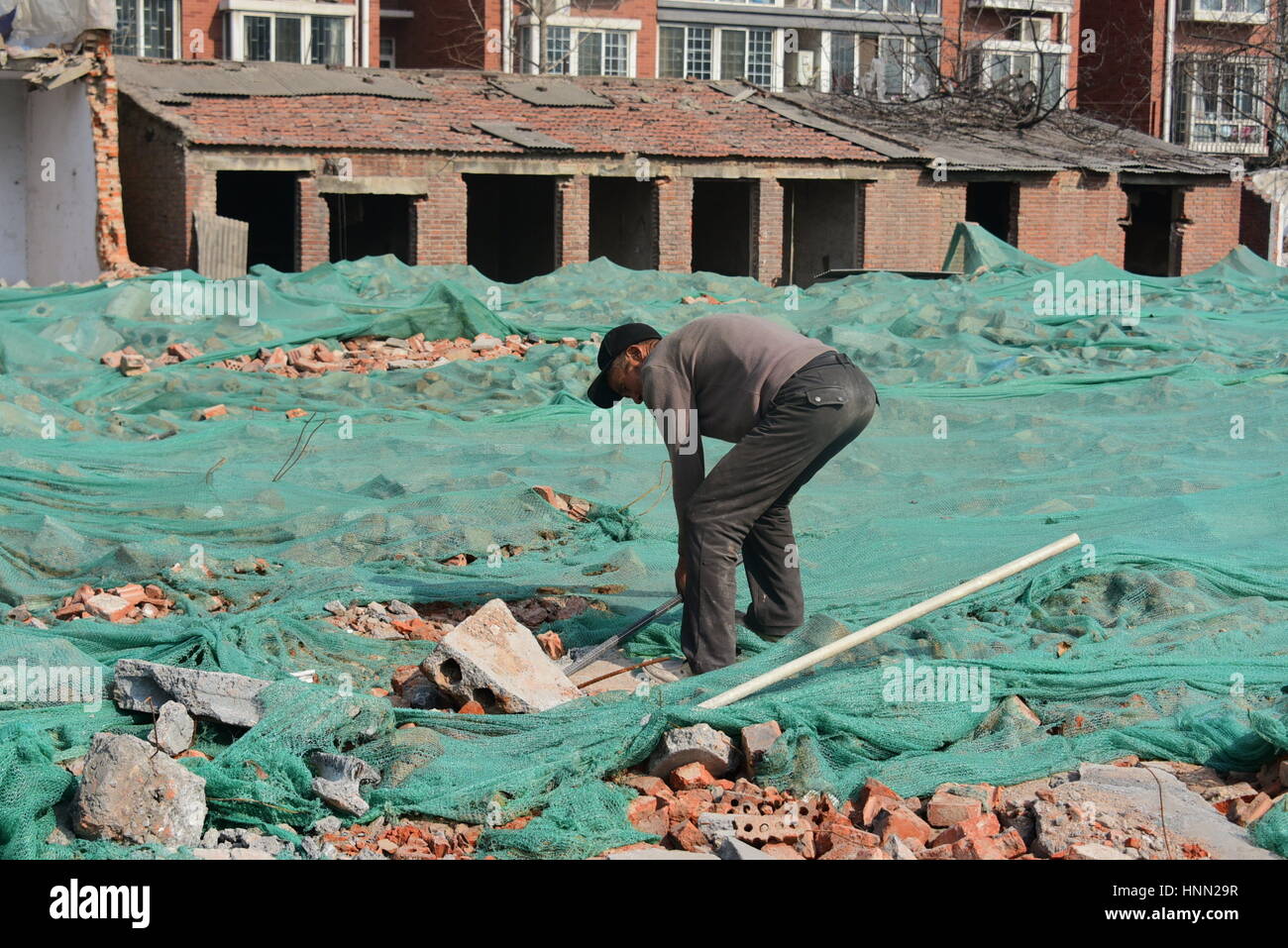 Zhengzh, Zhengzh, China. 15th Feb, 2017. Zhangzhou, CHINA-February 15 2017: (EDITORIAL USE ONLY. CHINA OUT) .A migrant worker searches concrete reinforcing bars at the ruins of construction sites in Zhengzhou, capital of central China's Henan Province, February 15th, 2017. Some migrant workers pick concrete at ruins and smash irons out of the concretes, trying to sell the irons. However, there aren't so many irons in the concrete, and they can only earn less than 10 yuan (US$1.5) every day by smashing irons out of concrete. Credit: SIPA Asia/ZUMA Wire/Alamy Live News Stock Photo