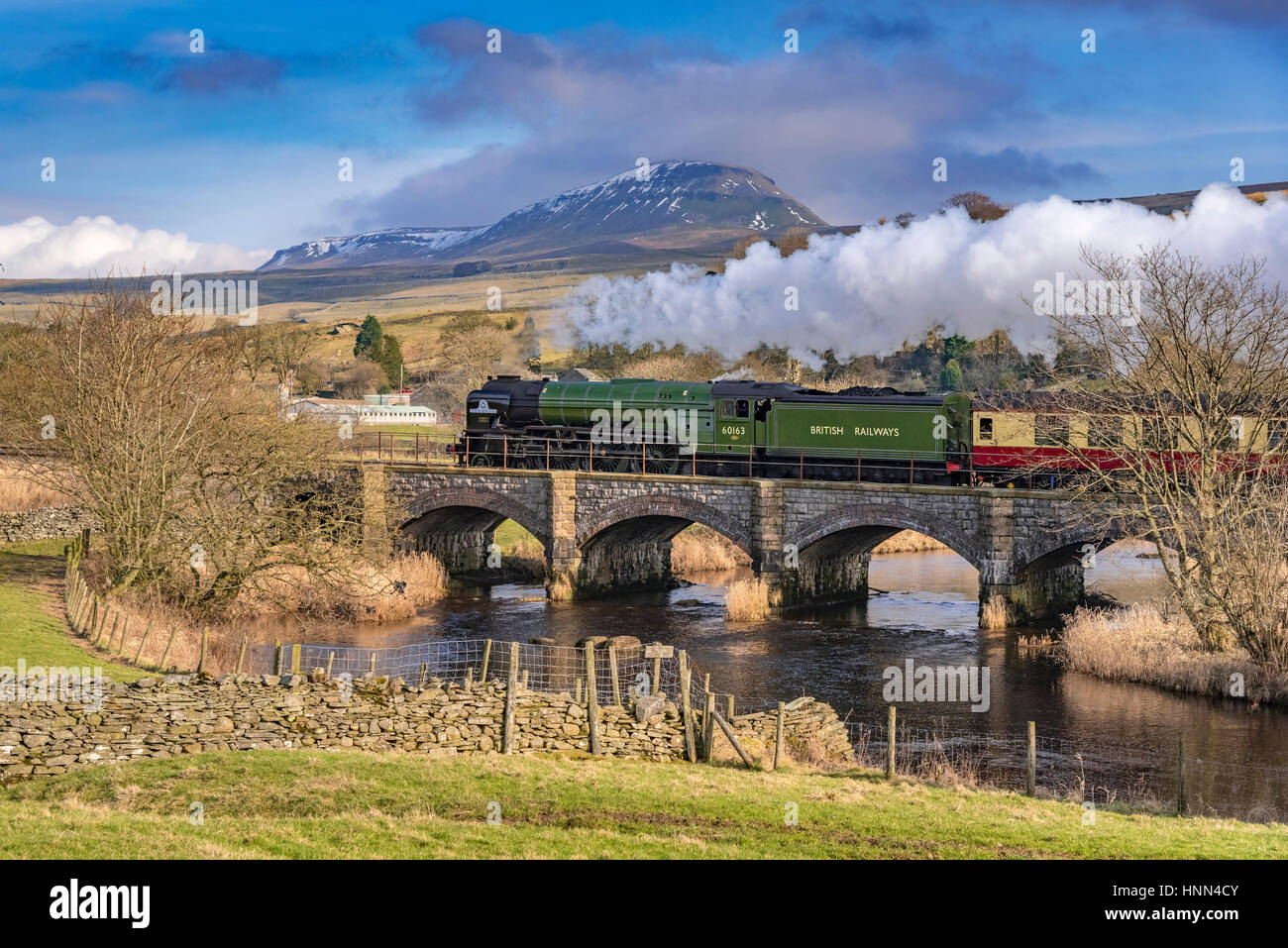 Helwith Bridge. North Yorkshire. North West England. Wednesday 15th February 2017. The Peppercorn steam engine Tornado on the secnond day of hauling scheduled trains between Skipton and Appleby on the Settle to Carlisle railway. The services are the first schedueld steam hauled services on British rail for 50 years. The train is pictured passing over Helwith Bridge with the towering Pen Y Ghent in the background. Picture by Andrew Davidson. Stock Photo